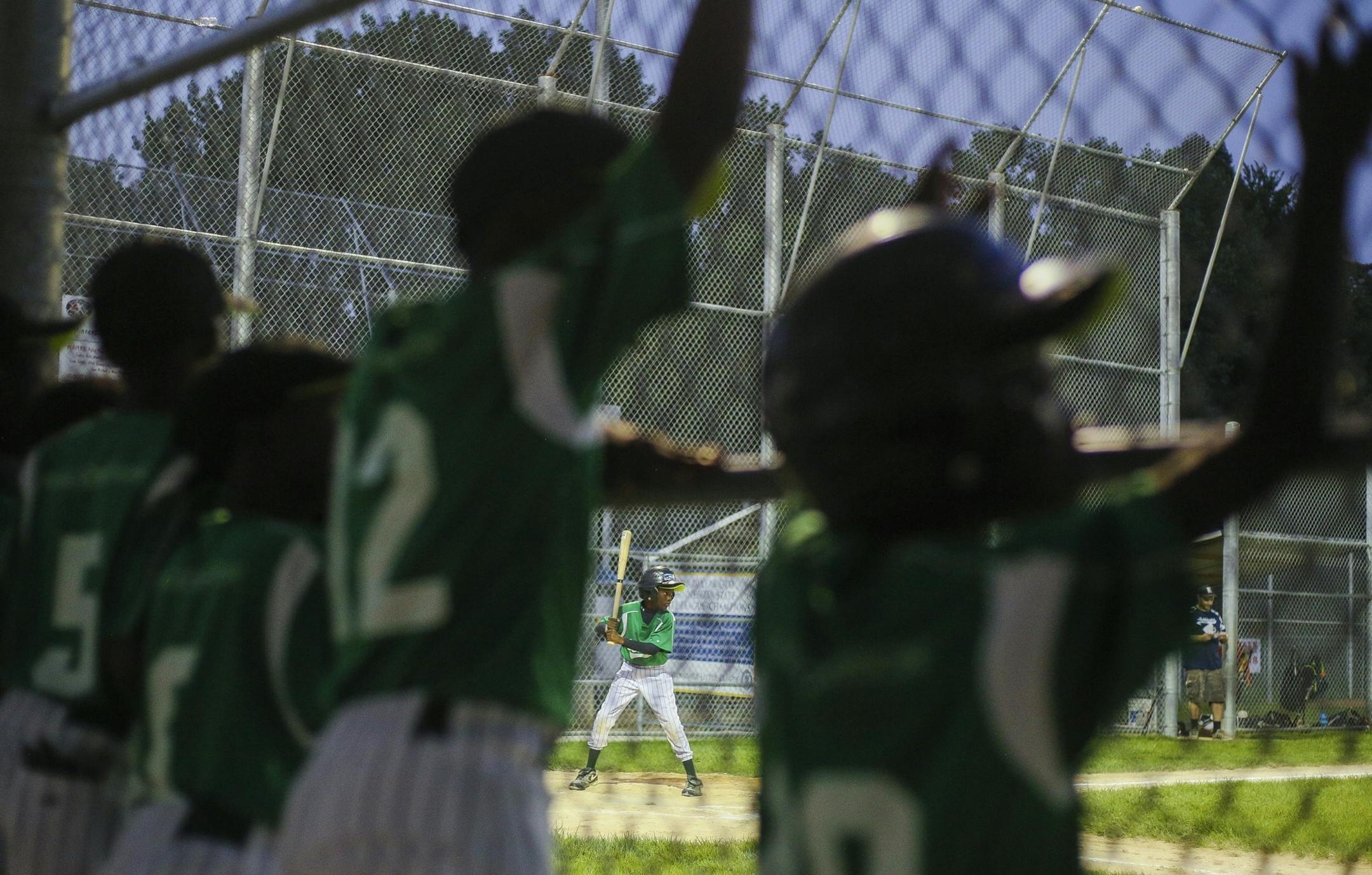 Teammates watch as Vibel Aboue, center, takes an at-bat during their scrimmage against the Robbinsdale 10-year-old all-star team at Lakeview Terrace Park on Tuesday, August 2, 2016 in Robbinsdale.