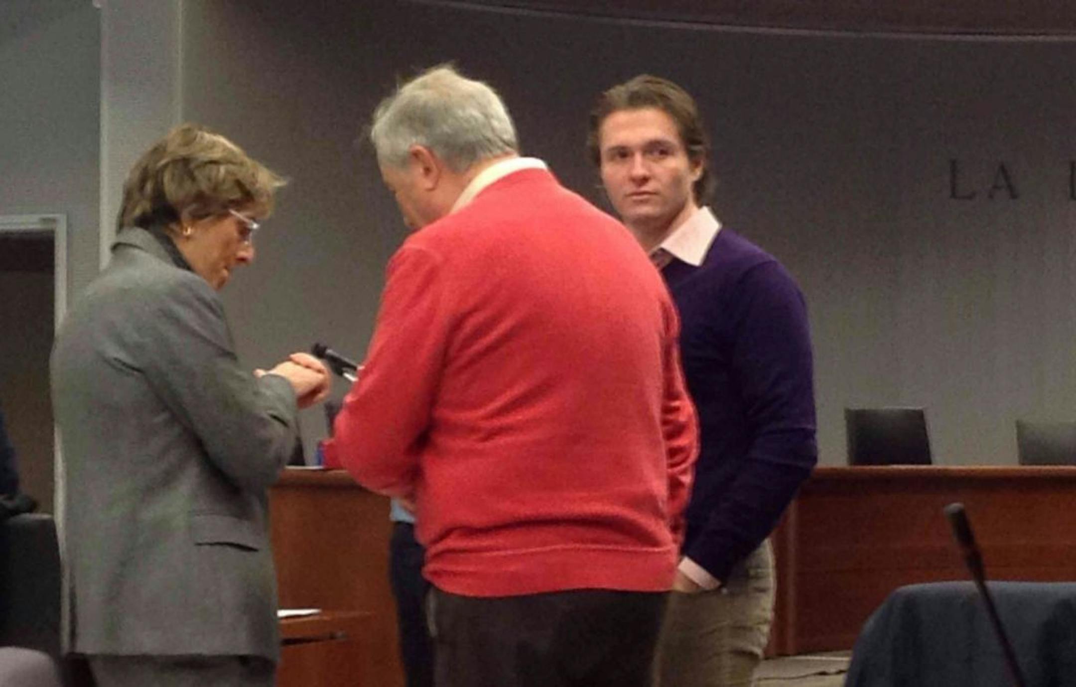 In this picture taken with a mobile phone, US student Amanda Knox's Italian ex-boyfriend Raffaele Sollecito, right, stands up with his lawyer Giulia Bongiorno, left, and his father Francesco during of a hearing in Sollecito and Knox's trial at an appeals court in Florence, Italy, Monday, Nov. 25, 2013.