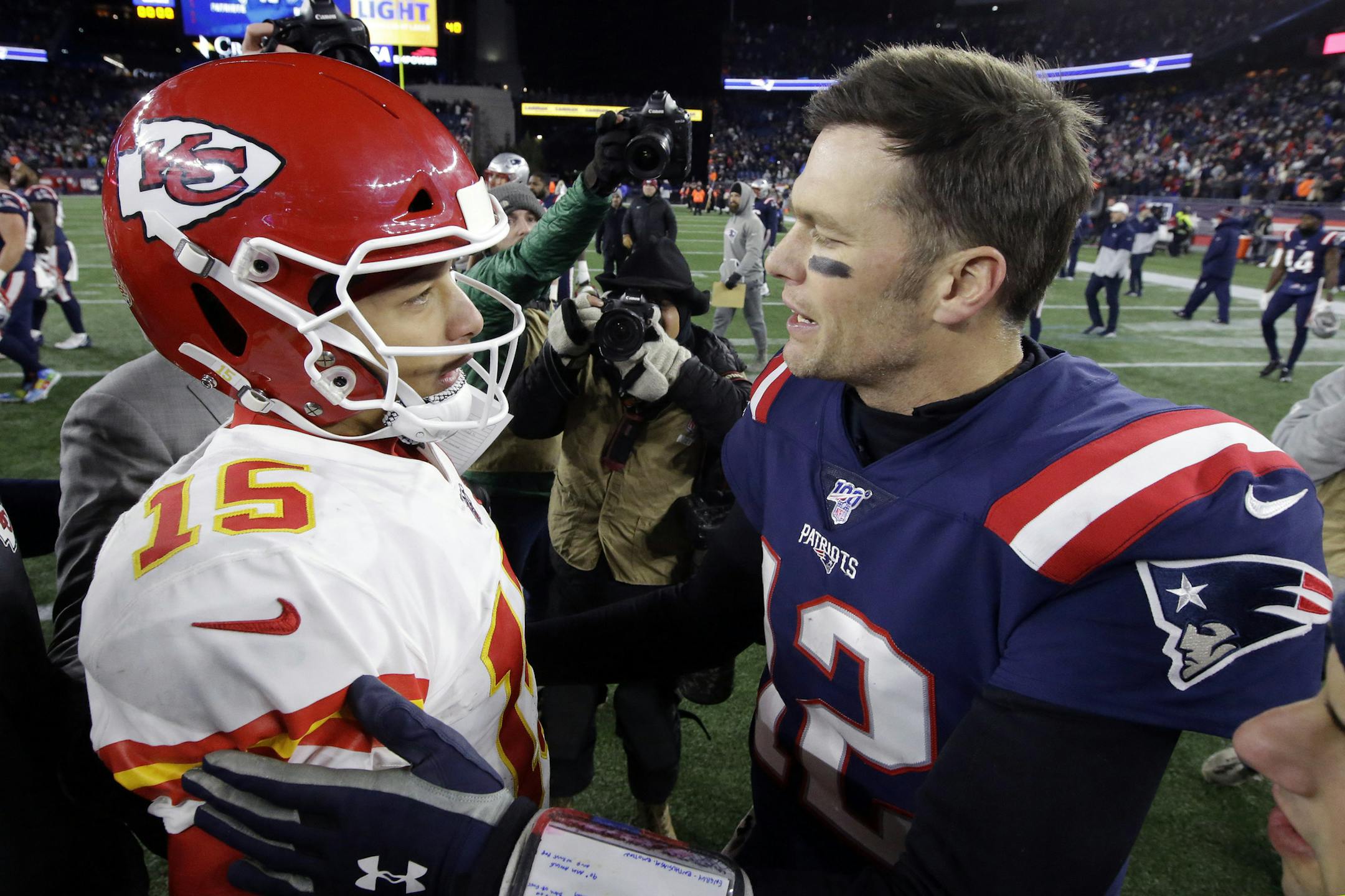 Kansas City Chiefs quarterback Patrick Mahomes, left, and New England Patriots quarterback Tom Brady speak at midfield after an NFL football game, Sunday, Dec. 8, 2019, in Foxborough, Mass. (AP Photo/Steven Senne)