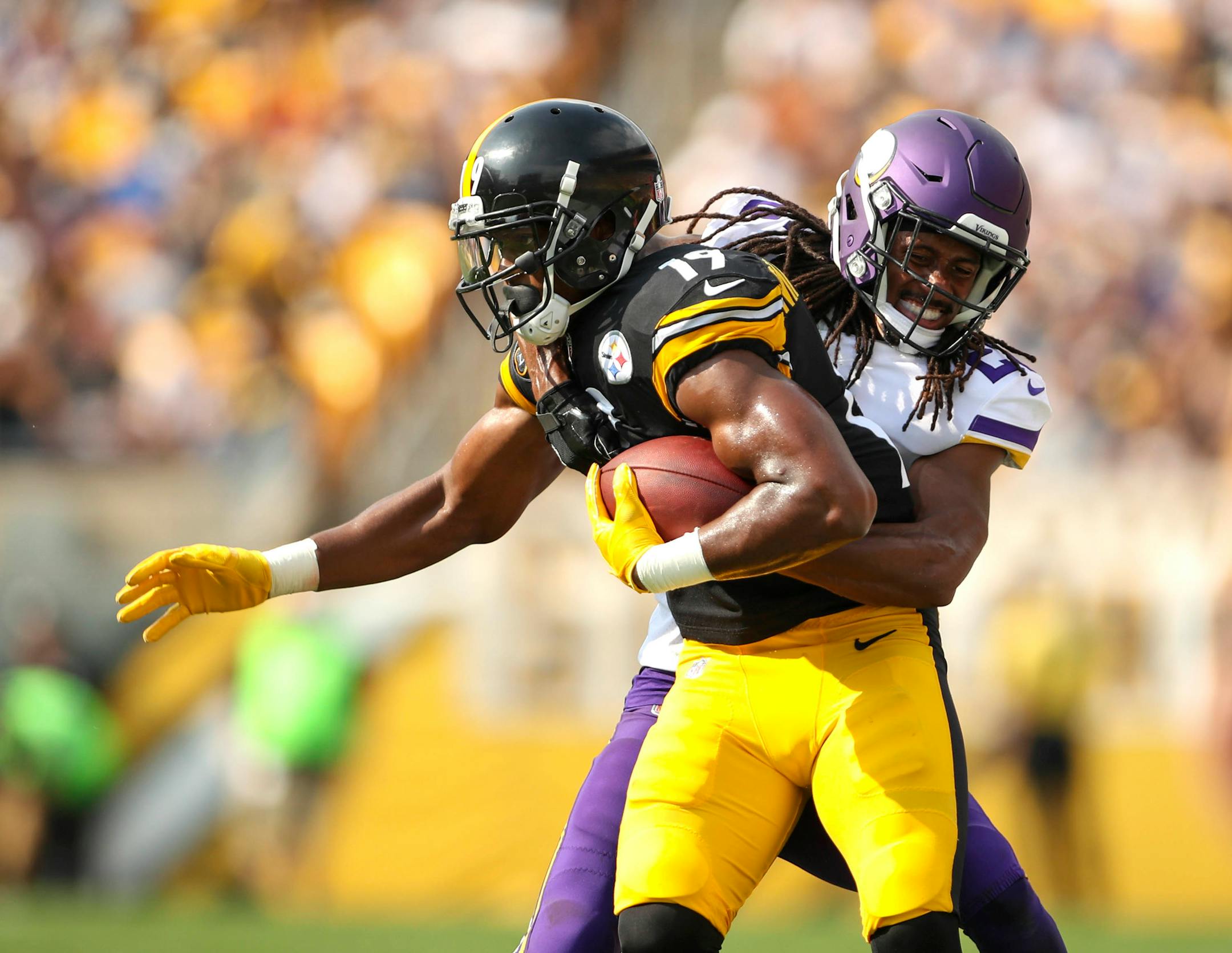 Pittsburgh Steelers wide receiver JuJu Smith-Schuster (19) dragged along Minnesota Vikings cornerback Trae Waynes (26) after gaining 9 yards for a fourth quarter first down.