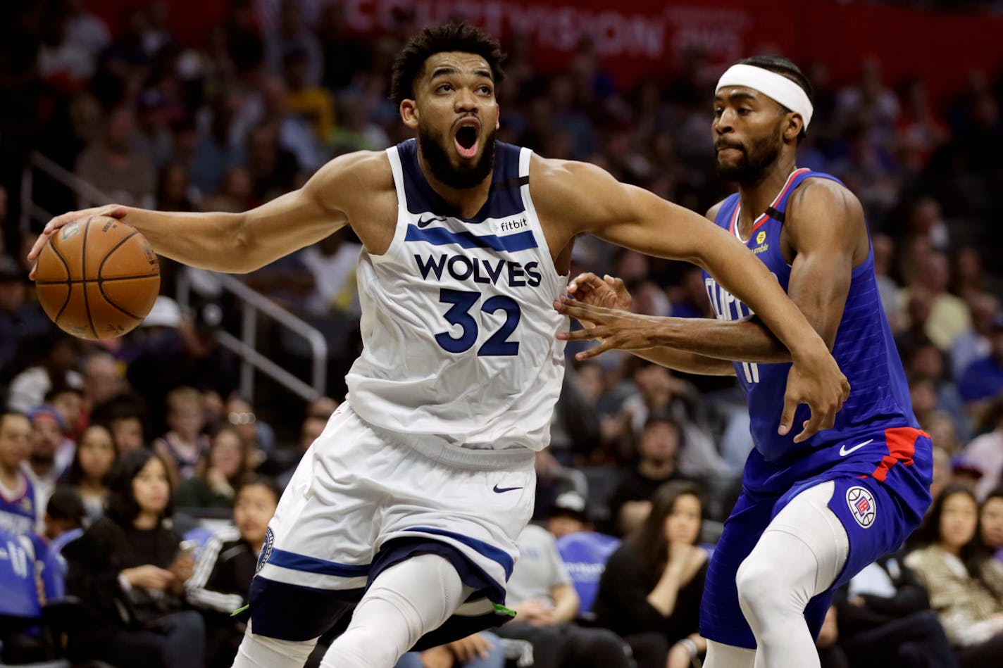 Minnesota Timberwolves center Karl-Anthony Towns, left, drives past Los Angeles Clippers forward Maurice Harkless during the first half of an NBA basketball game in Los Angeles, Saturday, Feb. 1, 2020. (AP Photo/Alex Gallardo)