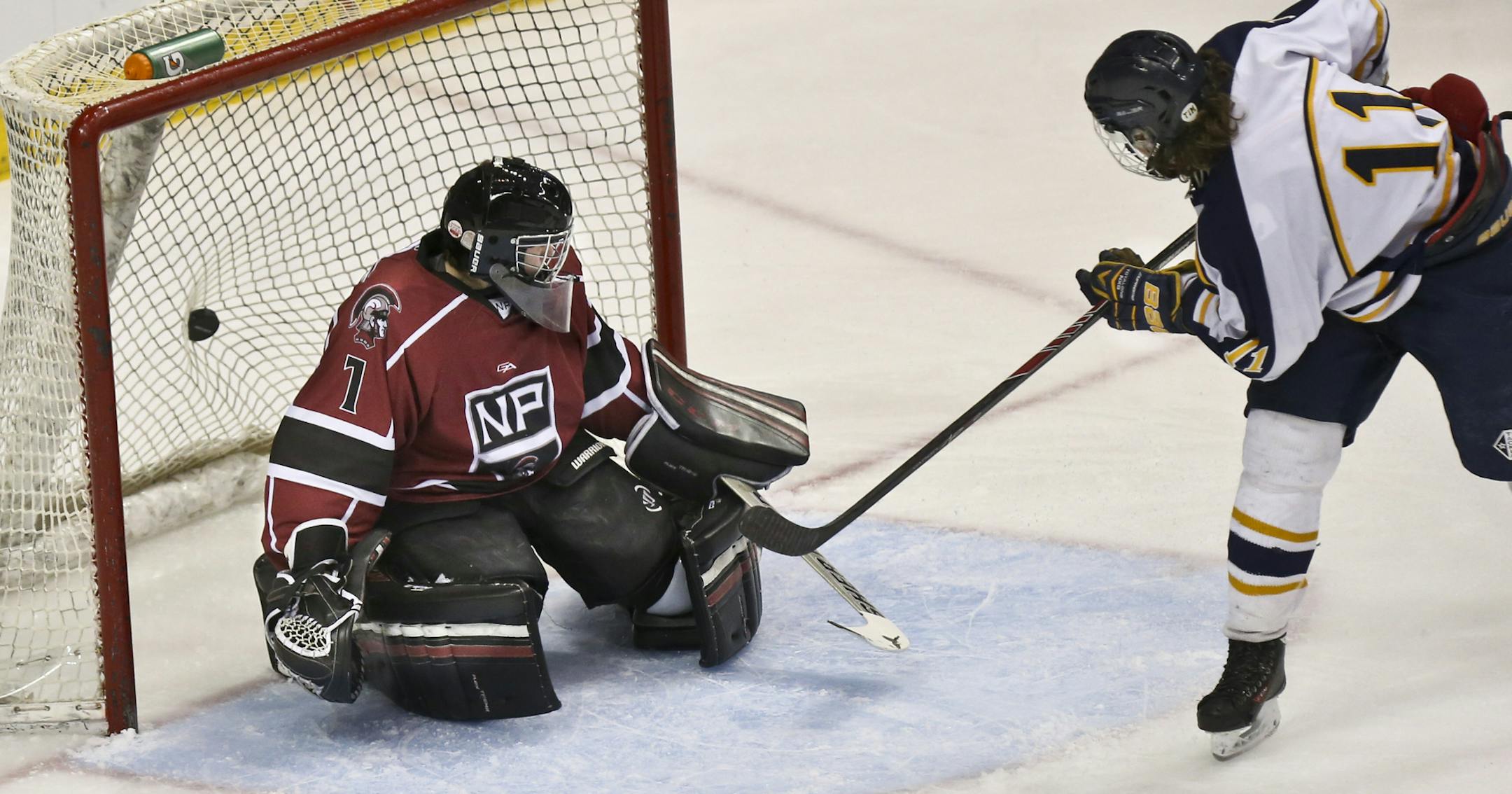 Hermantown's Ryan Carlson scored on New Prague goalie Connor Wagner in the first period during the boys' hockey tournament 1A semifinals.