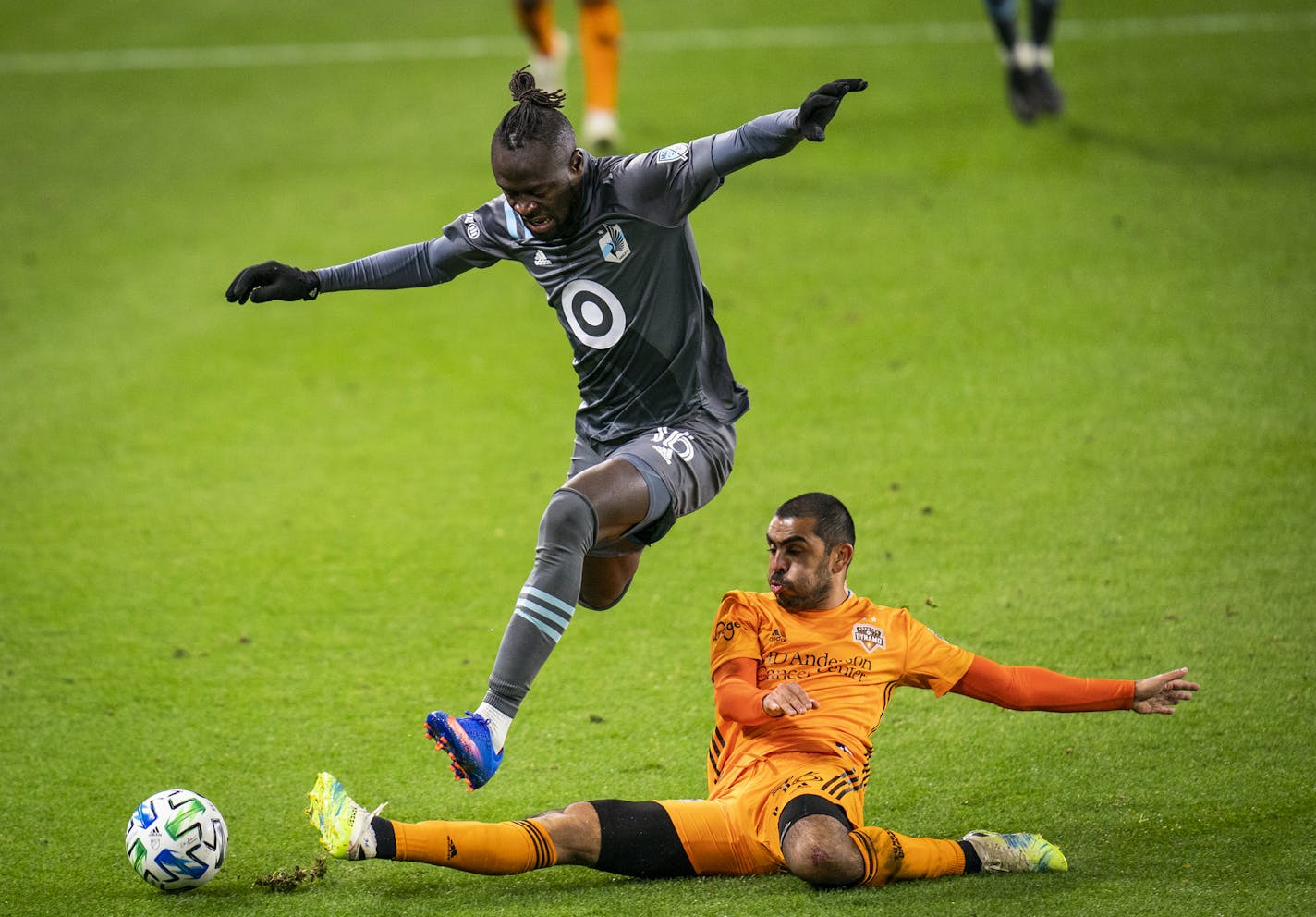 Minnesota United forward Kei Kamara (16) jumped over Houston Dynamo defender Victor Cabrera (36) during the second half of an MLS match in St. Paul, Minn., Sunday, Oct. 18, 2020. (Leila Navidi/Star Tribune via AP)