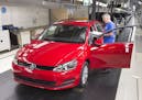 Hans-Dieter Hoigt checks the production car papers at a Volkswagen Golf and Passat plant in Germany, Sunday, Sept. 6, 2015.
