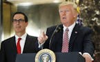 President Donald Trump, accompanied by Treasury Secretary Steven Mnuchin, speaks to the media in the lobby of Trump Tower in New York, Tuesday, Aug. 1