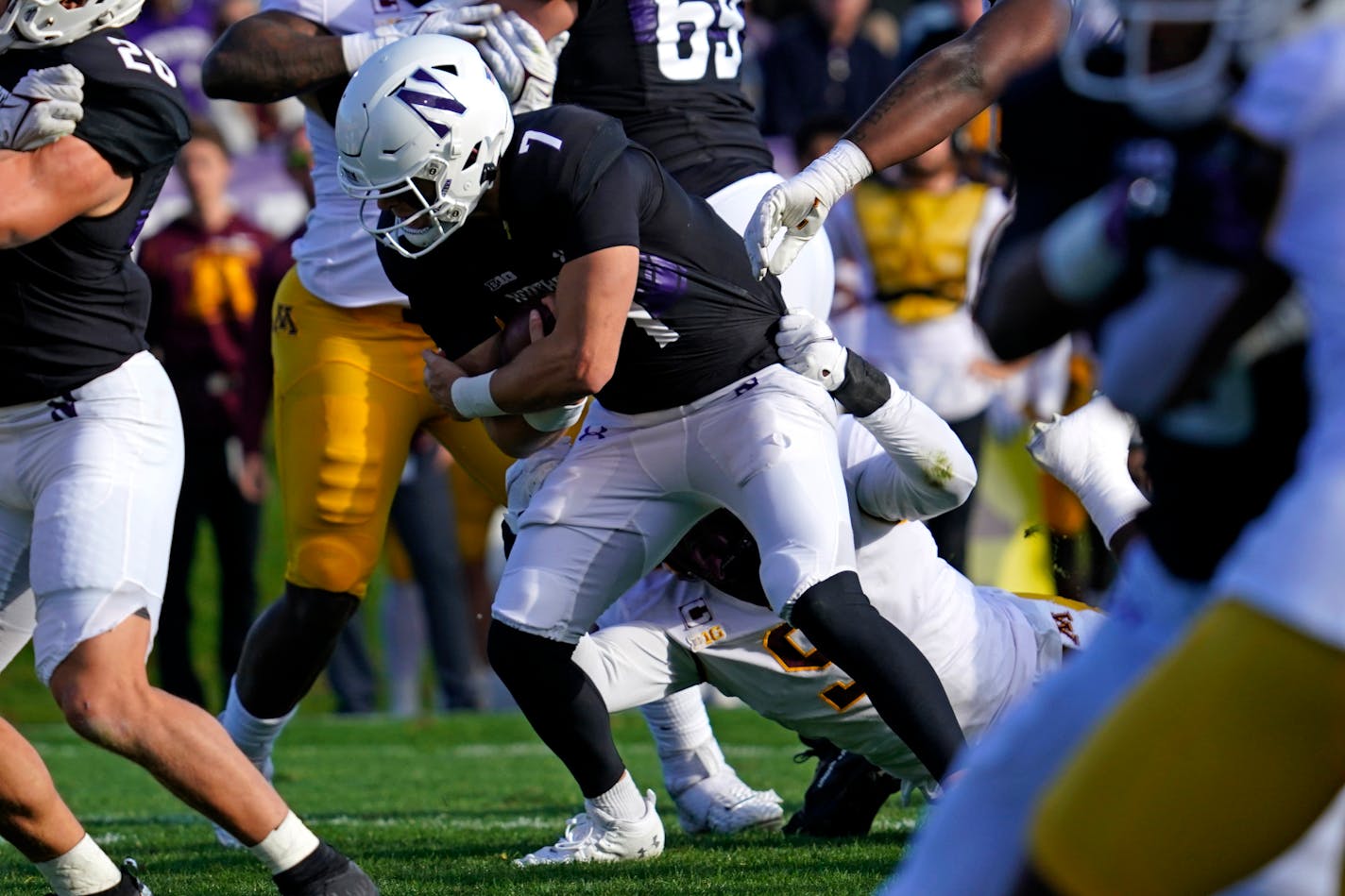 Northwestern quarterback Andrew Marty (7) is tackled by Minnesota defensive lineman Esezi Otomewo during the first half of an NCAA college football game in Evanston, Ill., Saturday, Oct. 30, 2021. (AP Photo/Nam Y. Huh)