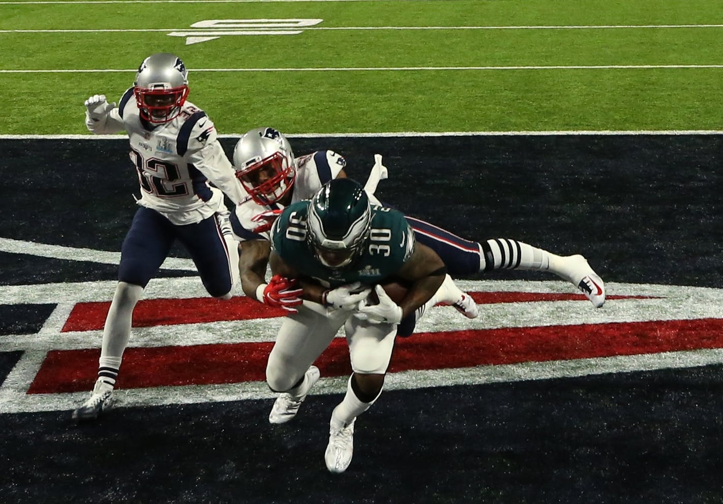 Philadelphia Eagles running back Corey Clement (30) made a 22-yard touchdown catch in the third quarter of Super Bowl LII as Devin McCourty (32) and Marquis Flowers of the New England Patriots tried to defend.