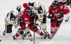 Western Michigan's Drew Worrad (13) and Jamie Rome (20) battled with St. Cloud State's Nolan Walker (20) and Micah Miller (15) for the puck during an 