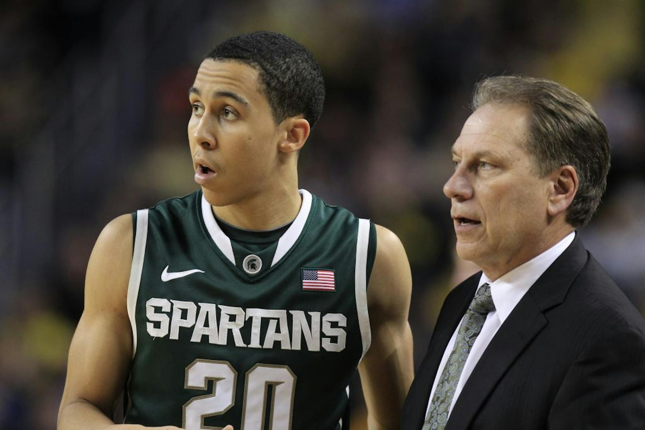 Michigan State head coach Tom Izzo talks with guard Travis Trice (20) during the second half of an NCAA college basketball game against Michigan in Ann Arbor, Mich., Tuesday, Jan. 17, 2012.
