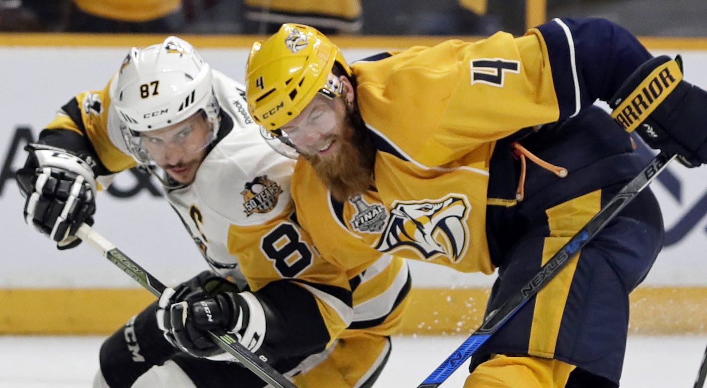 Nashville Predators defenseman Ryan Ellis (4) and Pittsburgh Penguins center Sidney Crosby (87) battle for the puck during the second period in Game 3 of the NHL hockey Stanley Cup Finals Saturday, June 3, 2017, in Nashville, Tenn. (AP Photo/Mark Humphrey)