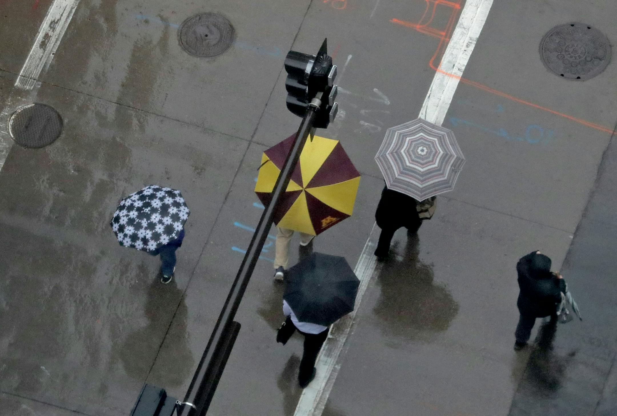 Seen from above at the corner of S. 6th St. and 2nd Avenue S. umbrella-protected commuters cross the street Wednesday, April 26, 2017, in downtown Minneapolis, MN.] DAVID JOLES ï david.joles@startribune.com Steady, cold rain Wednesday