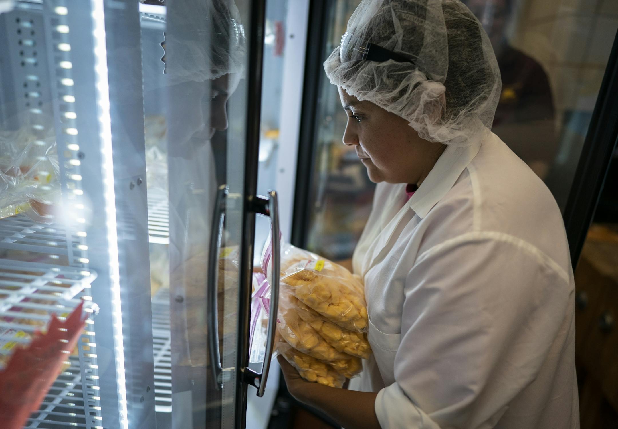 U student Sam Stitt restocks the cheese curds in the Meat and Dairy salesroom.