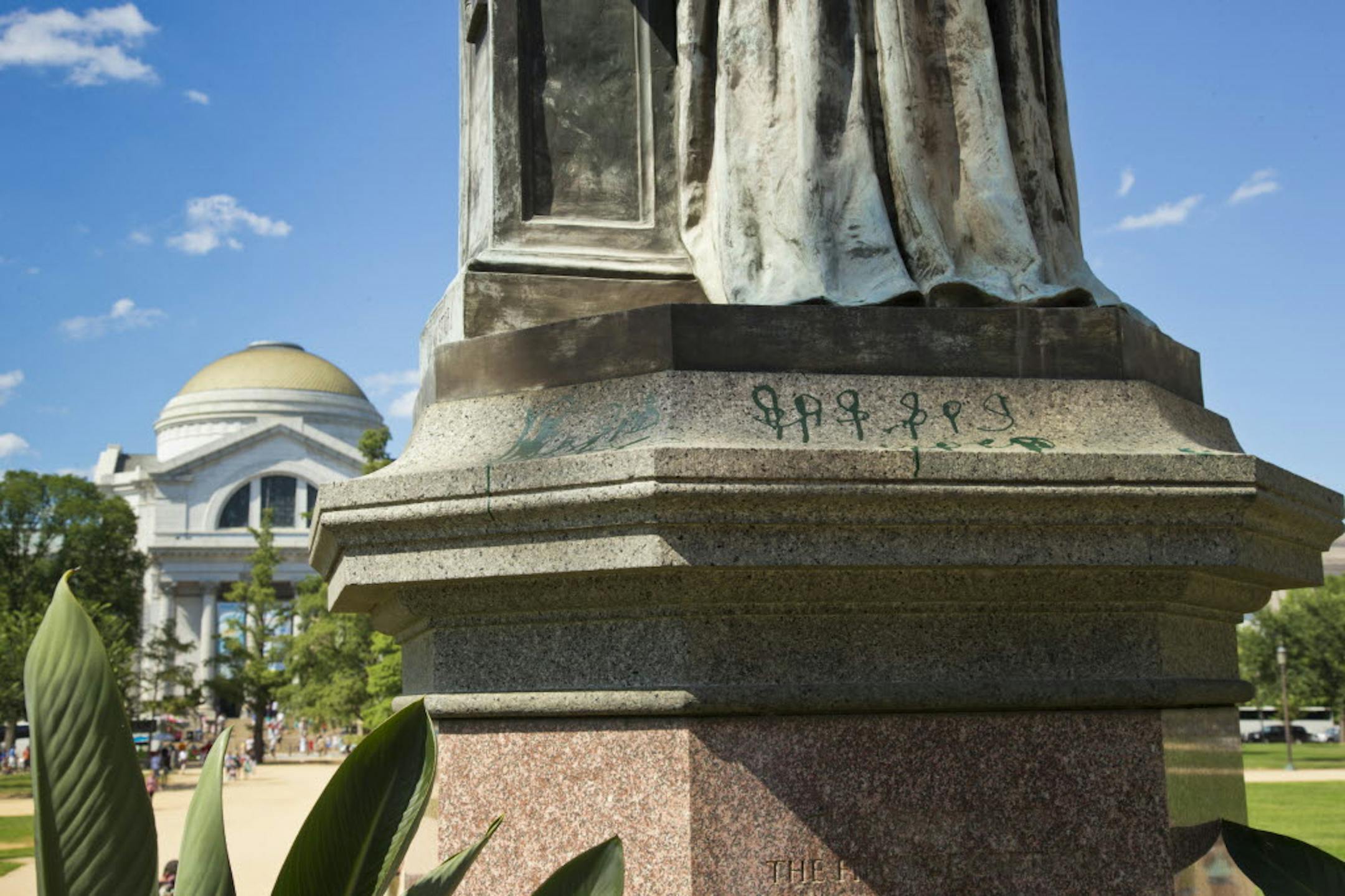 Green paint is seen on the pedestal of the statue of Joseph Henry, outside the headquarters of the Smithsonian Institution, in Washington, Monday.
