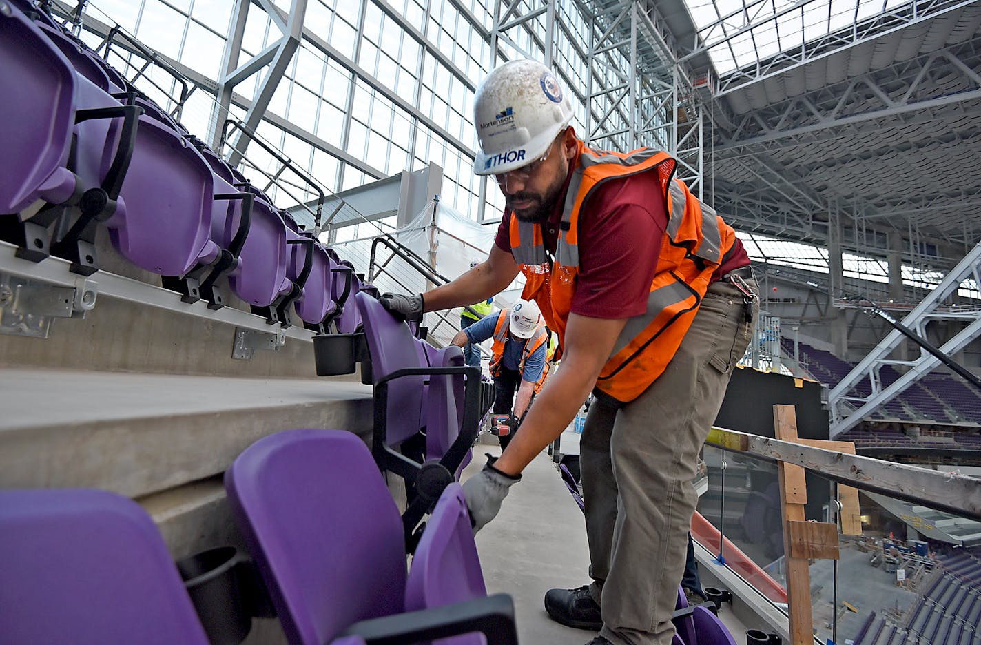 Workers install two rows of seats in section 349 of U.S. Bank Stadium, the new home of the Minnesota Vikings, in Minneapolis on Friday.