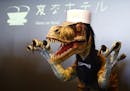 A receptionist dinosaur robot performs at the new robot hotel, aptly called Henn na Hotel or Weird Hotel, in Sasebo, southwestern Japan, Wednesday, Ju