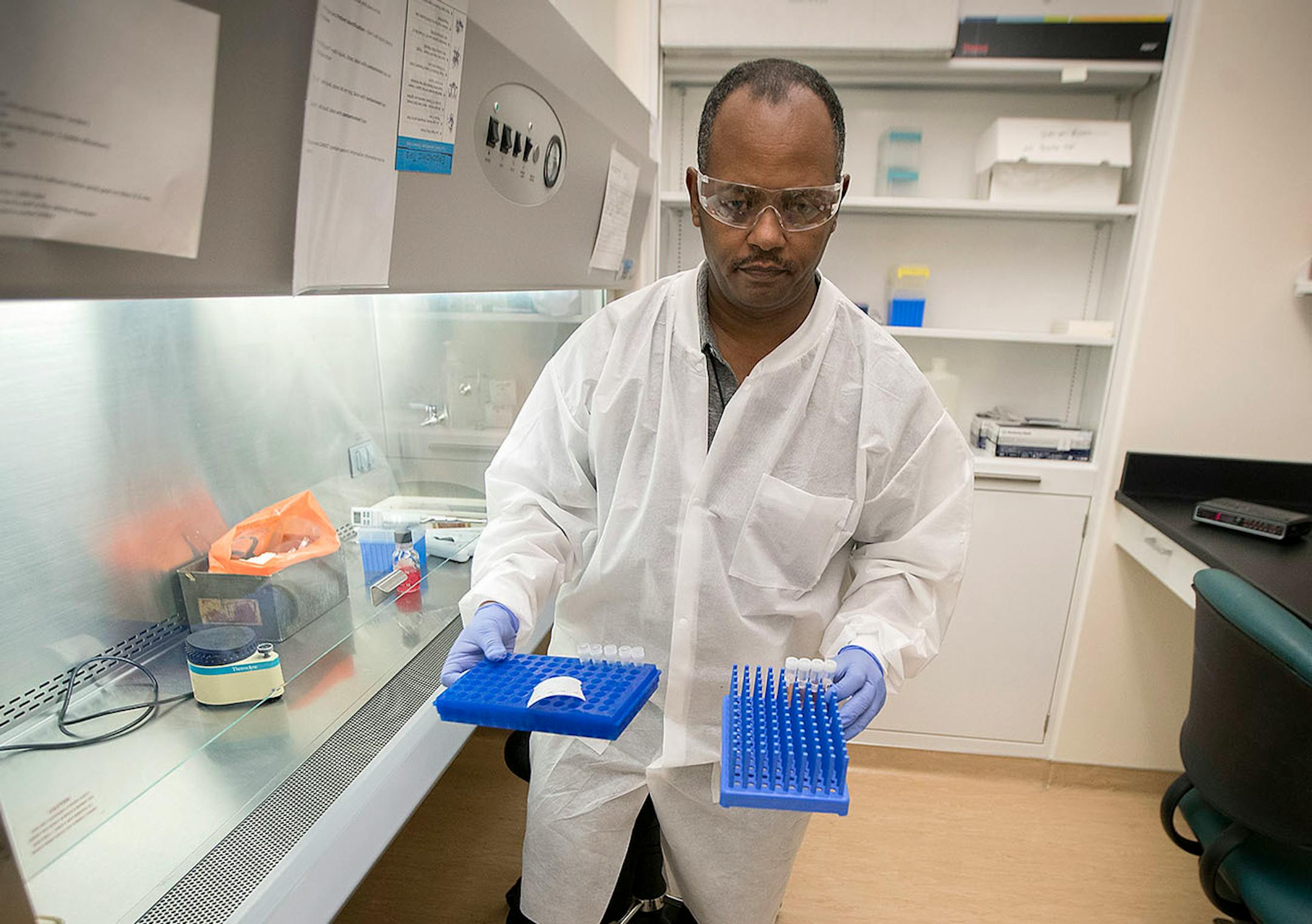 Netsanet Bekele, cq, a clinical lab scientist for the Minnesota Health Department test for measles as he places the tubes into a robot, Thursday, May 11, 2017 at the MHD laboratories in St. Paul, MN.