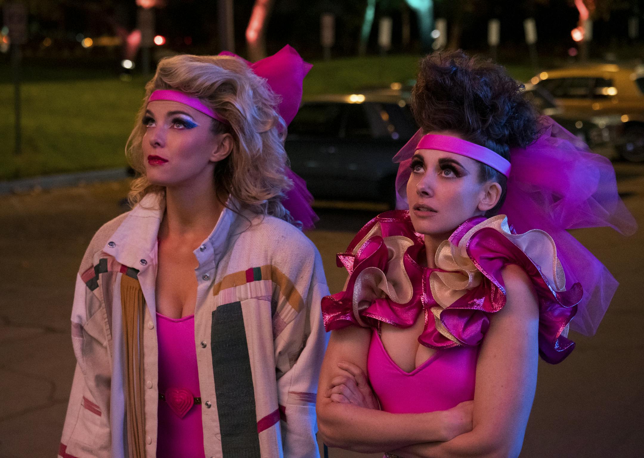 This image released by Netflix shows Betty Gilpin, left, and Alison Brie in a scene from "GLOW." On Tuesday, July 16, 2019, Gilpin was nominated for an Emmy Award for outstanding supporting actress in a comedy series. (Ali Goldstein/Netflix via AP)