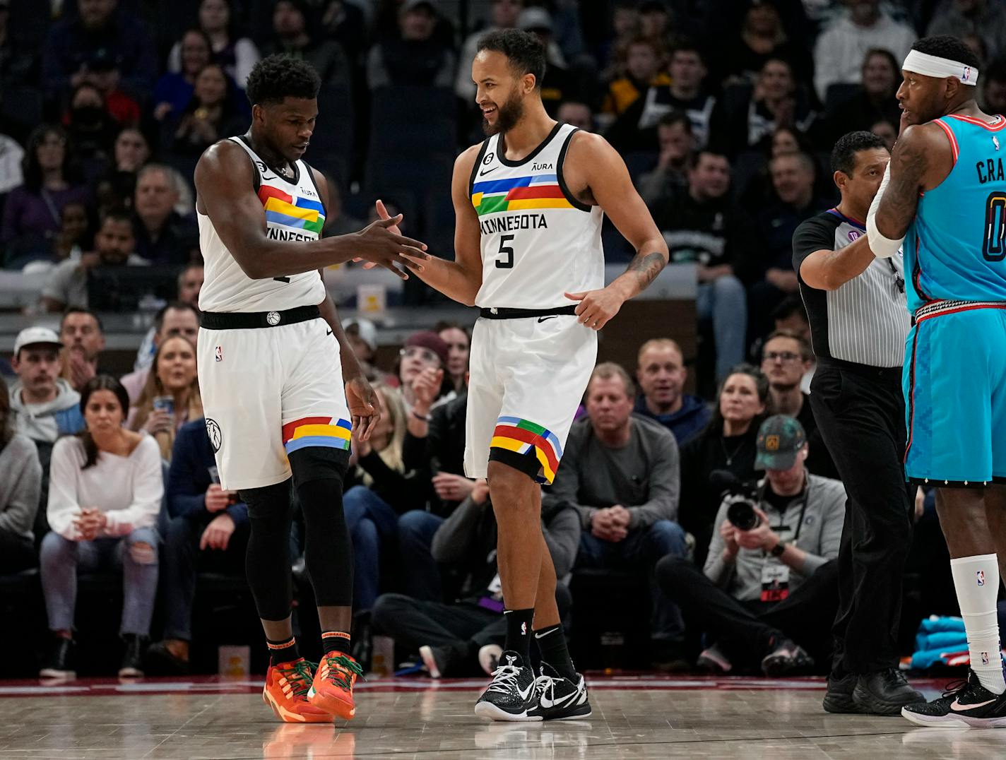 Timberwolves guard Anthony Edwards, left, and forward Kyle Anderson celebrate after a basket during the first half