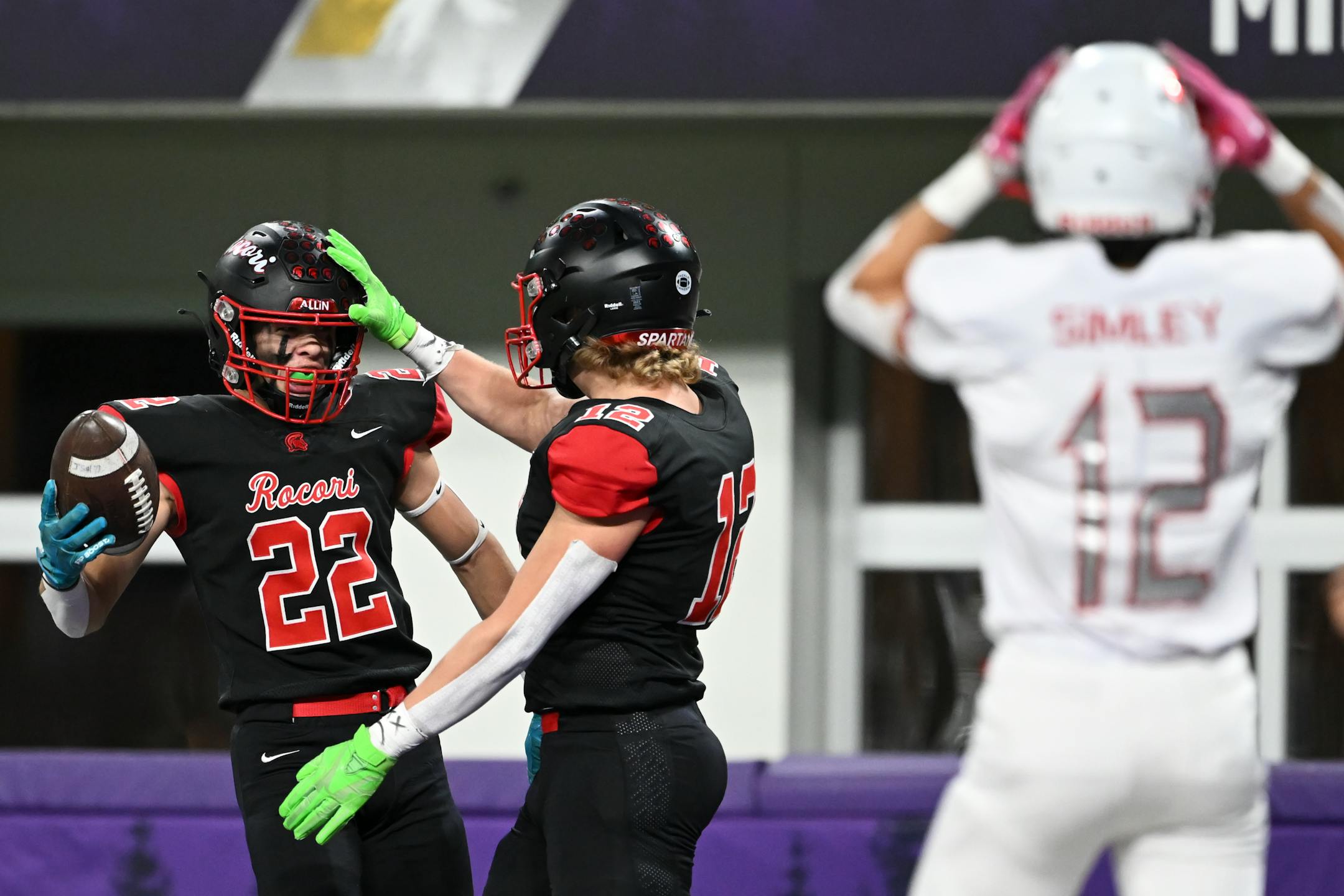 Rocori wide reciever Adam Langer (12) celebrates afer missing a catch and bobbling the ball back to teammate Gabe Johnson (22) for a touchdown during the first half.