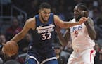 Minnesota Timberwolves center Karl-Anthony Towns, left, tries to drive past Los Angeles Clippers forward Montrezl Harrell during the first half of an 