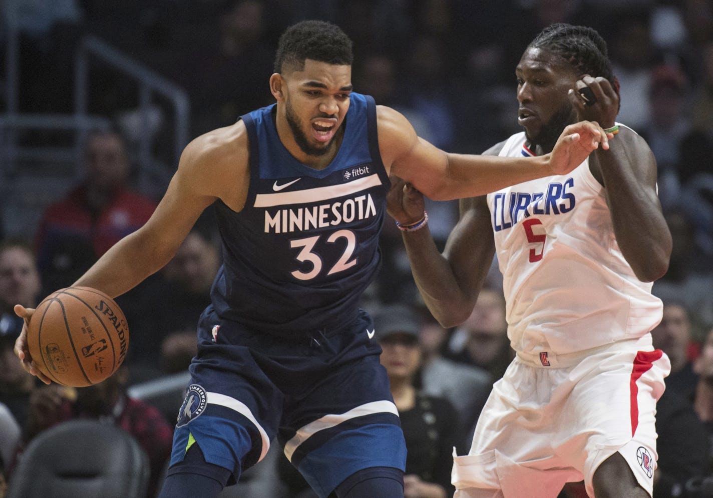 Minnesota Timberwolves center Karl-Anthony Towns, left, tries to drive past Los Angeles Clippers forward Montrezl Harrell during the first half of an NBA basketball game on Wednesday, Dec. 6, 2017, in Los Angeles.