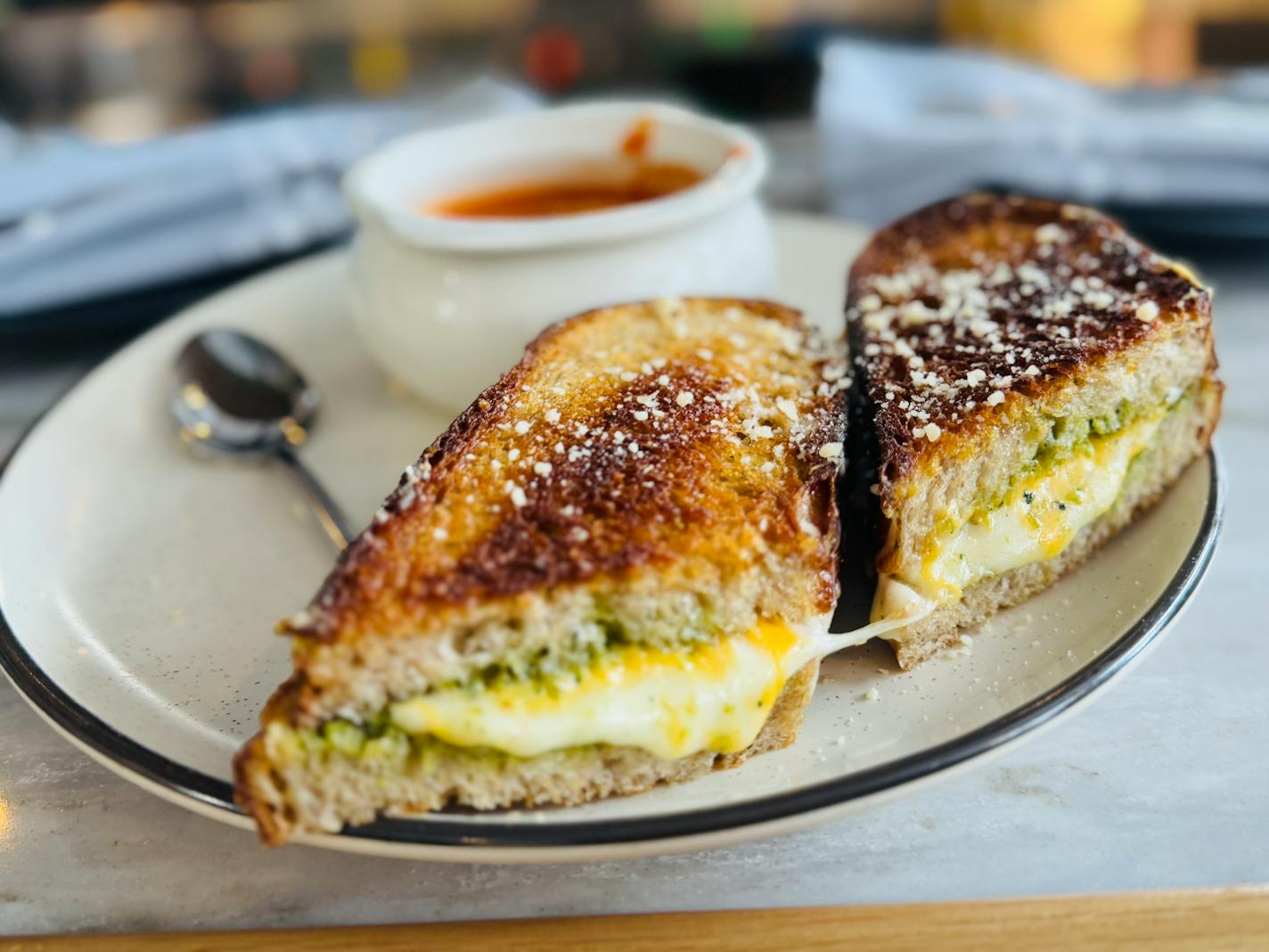 The gooey grilled cheese sandwich at Lynette in Minneapolis comes with four types of yellow and white cheeses and a bright green broccoli pesto.