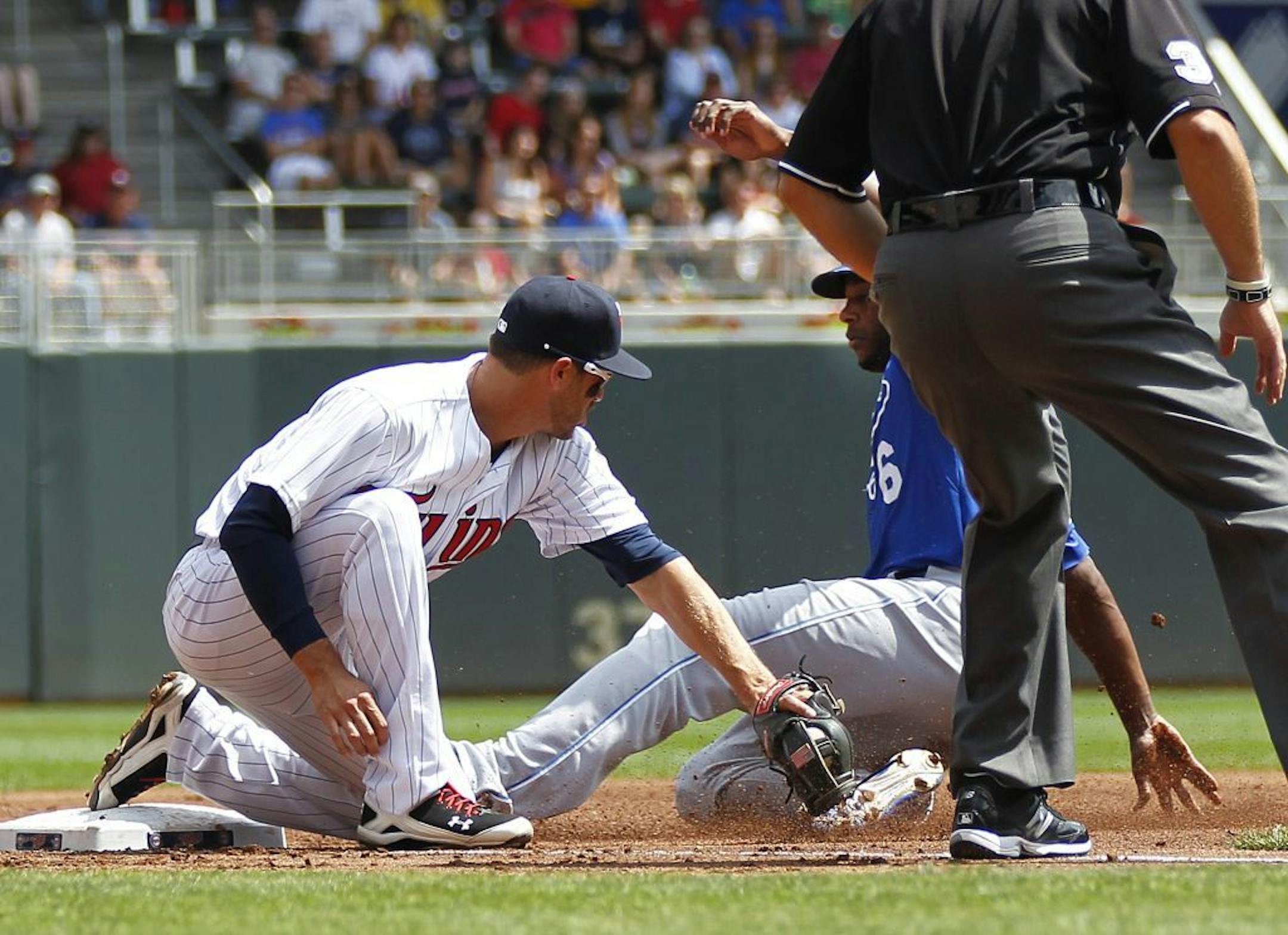 Kansas City Royals' Lorenzo Cain slides safely into third as Minnesota Twins third baseman Trevor Plouffe makes a late tag in the first inning of their baseball game in Minneapolis Thursday, Aug. 1, 2013.