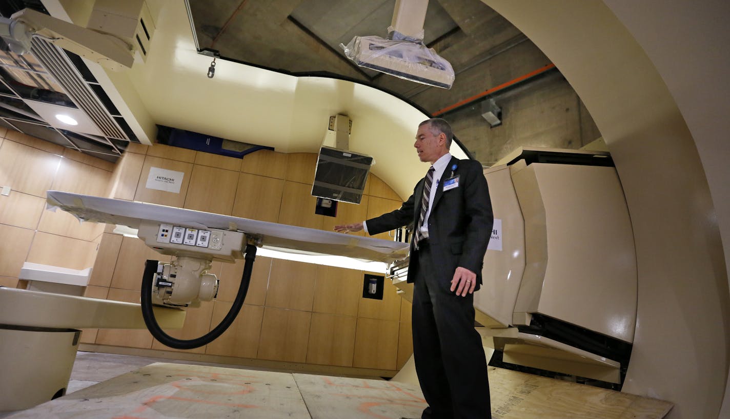 Michael Herman, Ph.D., consultant, Medical Physics, Mayo Clinic in Rochester, led a media tour of the Mayo's New Proton Beam Therapy Facility. Here he stands in one of four individual treatament rooms. Behind the wall is a massive three story Gantry. ] Construction on the Richard O. Jacobson Building, home to the Mayo Clinic proton beam therapy program, is now complete. Over the next 15 months, physicians, scientists and technicians will calibrate and test equipment in advance of the facility&#x