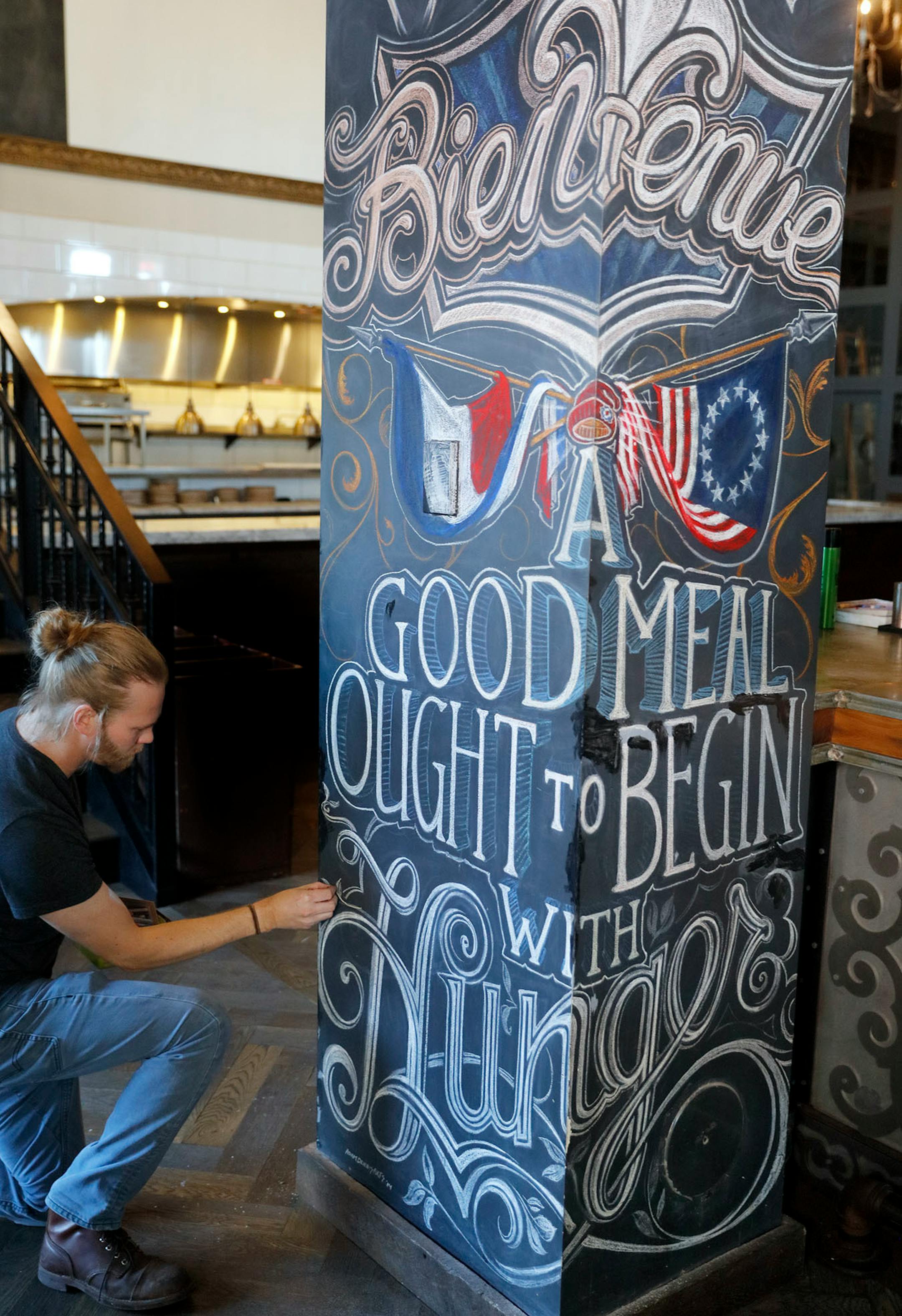Adam Dennis works on his murals at Coup d'Etat restaurant in Uptown. Dennis' work include Smack Shack and the Pourhouse and is done with chalk and spray paint.