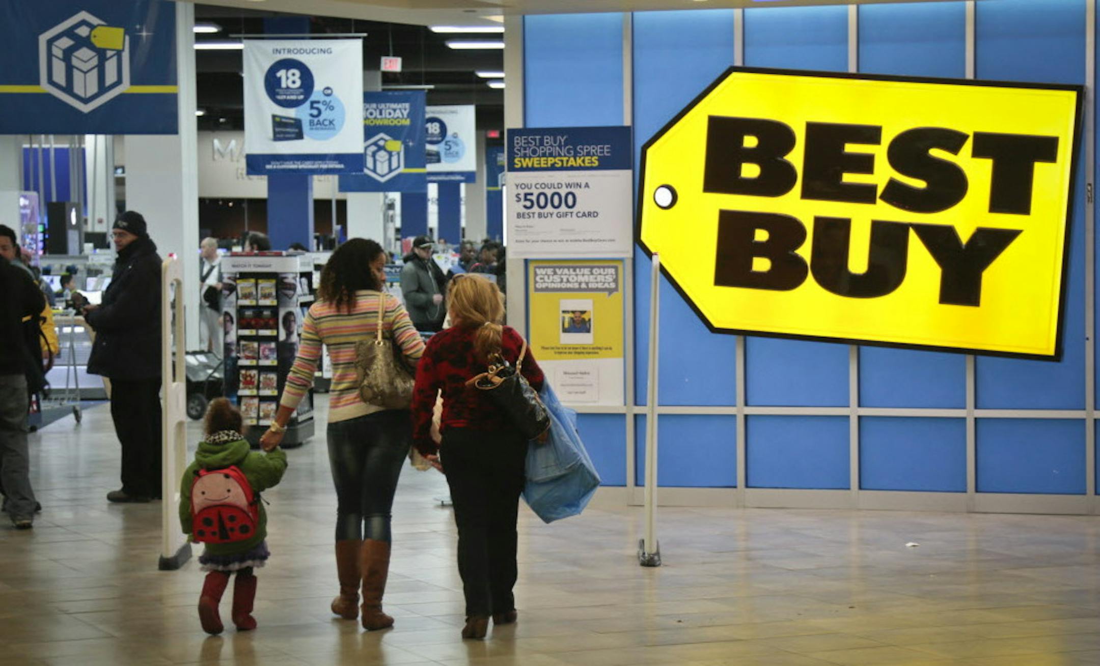 FILE - In this Nov. 23, 2013, file photo, shoppers enter a Best Buy in New York. In 2013, Best Buy slashed costs, ramped up employee training and matched online prices to draw customers into its stores. Best Buy has been stepping up its game as it faces competition from discounters and online retailers like Amazon.com. (AP Photo/Bebeto Matthews, File)