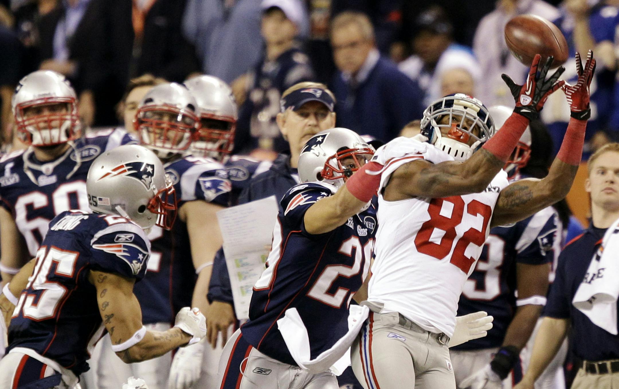 ADVANCE FOR WEEKEND EDITIONS, MARCH 10-11 - FILE - In this Feb. 5, 2012, file photo, New York Giants wide receiver Mario Manningham (82) catches a pass ahead of New England Patriots defensive back Sterling Moore, center, and safety Patrick Chung, left, during the second half of the NFL Super Bowl XLVI football game in Indianapolis. A week after a record 21 players were given franchise tags, the NFL's free agency free-for-all begins. As the the No. 3 receiver in the Meadowlands behind Hakeem Nick