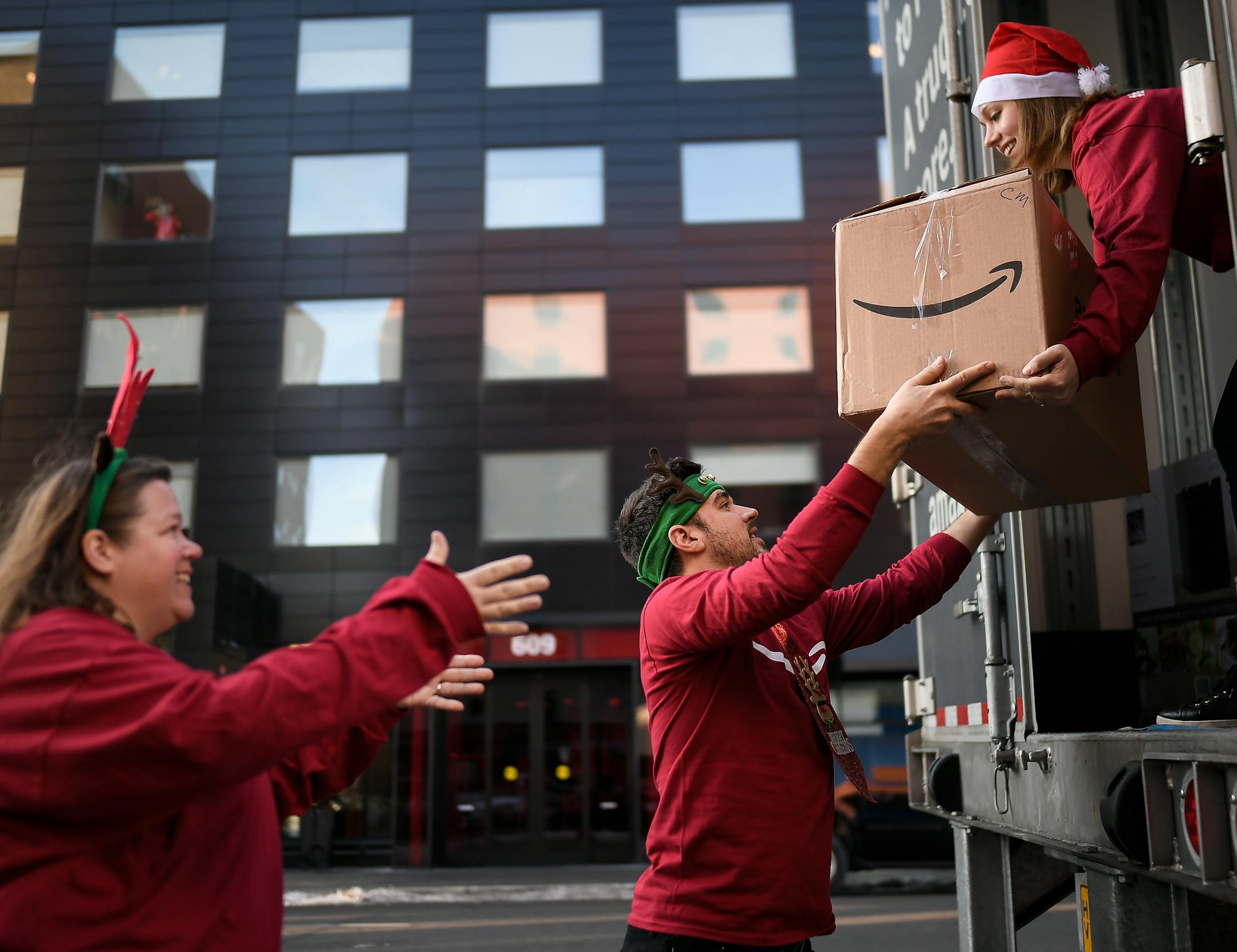 From left, Sara Citrano, Garrett DuPont and Katie Sand, employees at Amazon's Shakopee fulfillment center, worked on unloading Amazon's "sleigh," a semi truck filled with toys and essential items, which were given to families living at People Serving People in downtown Minneapolis. ] AARON LAVINSKY ï aaron.lavinsky@startribune.com The Amazon "sleigh," a semi truck filled with toys and essential items, stopped by Minneapolis shelter "People Serving People" to give away $15,000 worth of goods