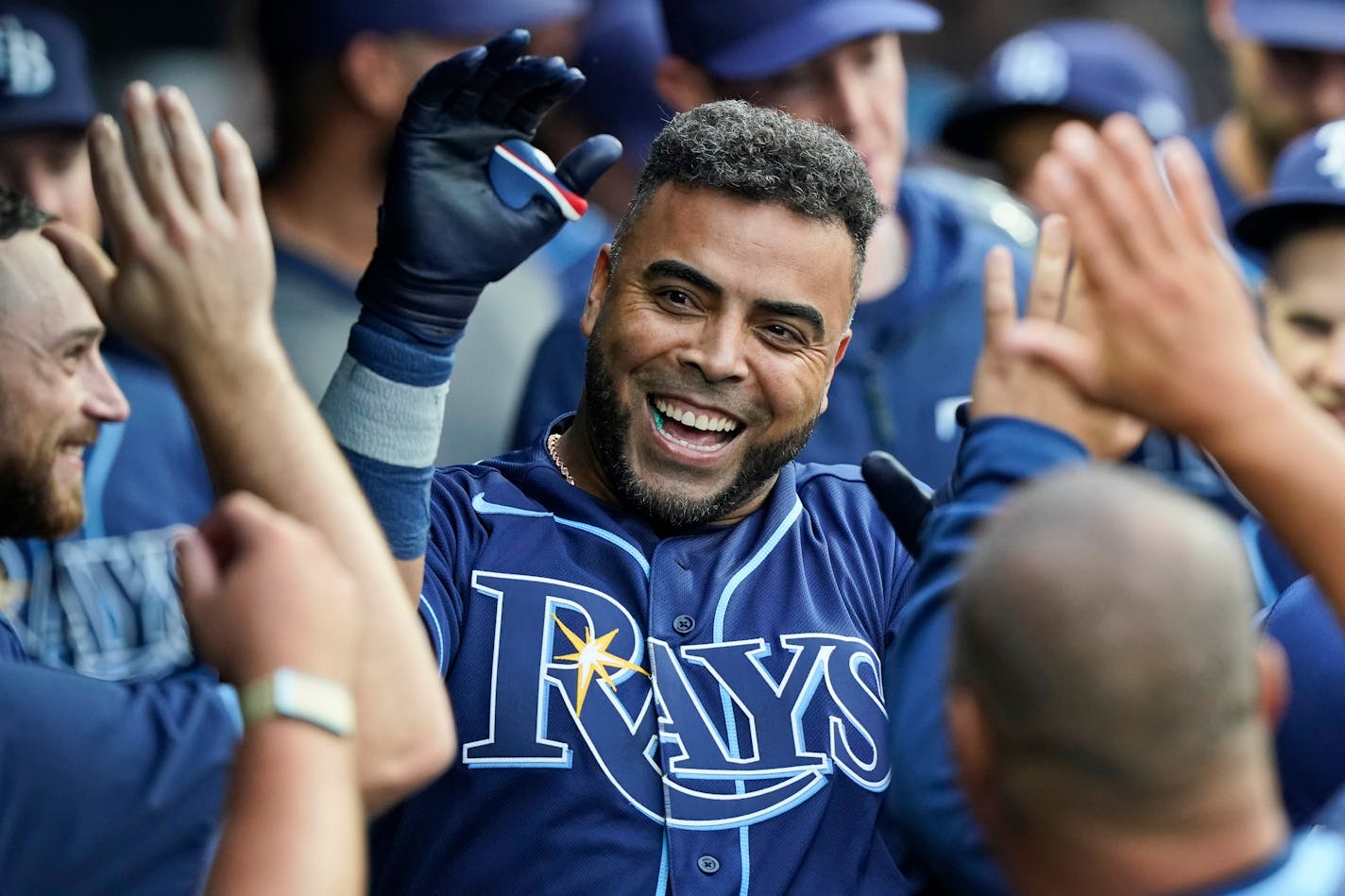 Tampa Bay Rays' Nelson Cruz is congratulated by teammates after hitting a solo home run during the third inning of the team's baseball game against the Cleveland Indians, Friday, July 23, 2021, in Cleveland. (AP Photo/Tony Dejak)