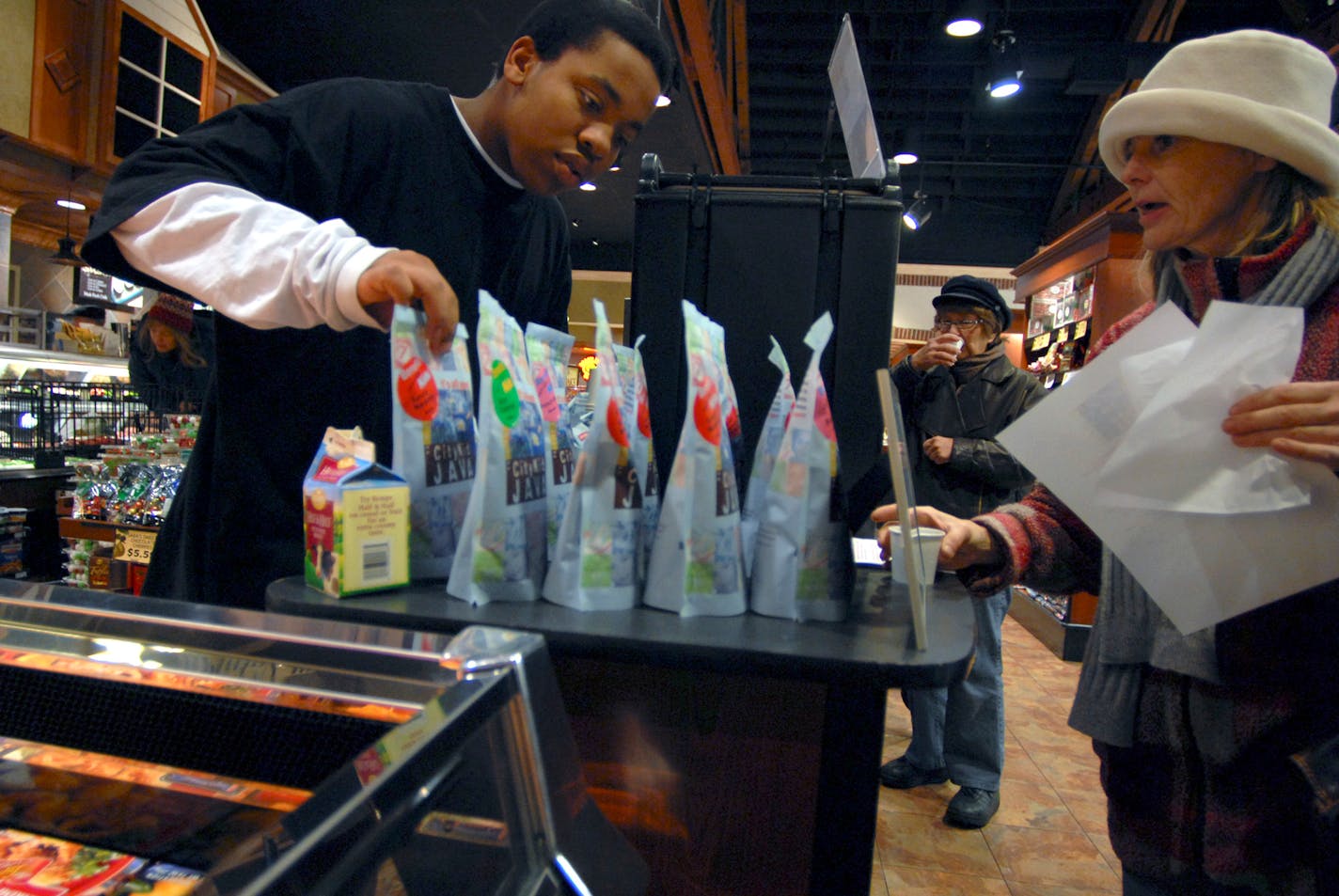 David Gholar, a sophomore at Roosevelt High School in Minneapolis, spent part of his 16th birthday selling Urban Venture's CityKid Java at a Kowalski's supermarket so he can adopt a few families for the holidays. Rose Danielson, right, said it was "a great idea" and bought some. He has become something of a coffee expert.