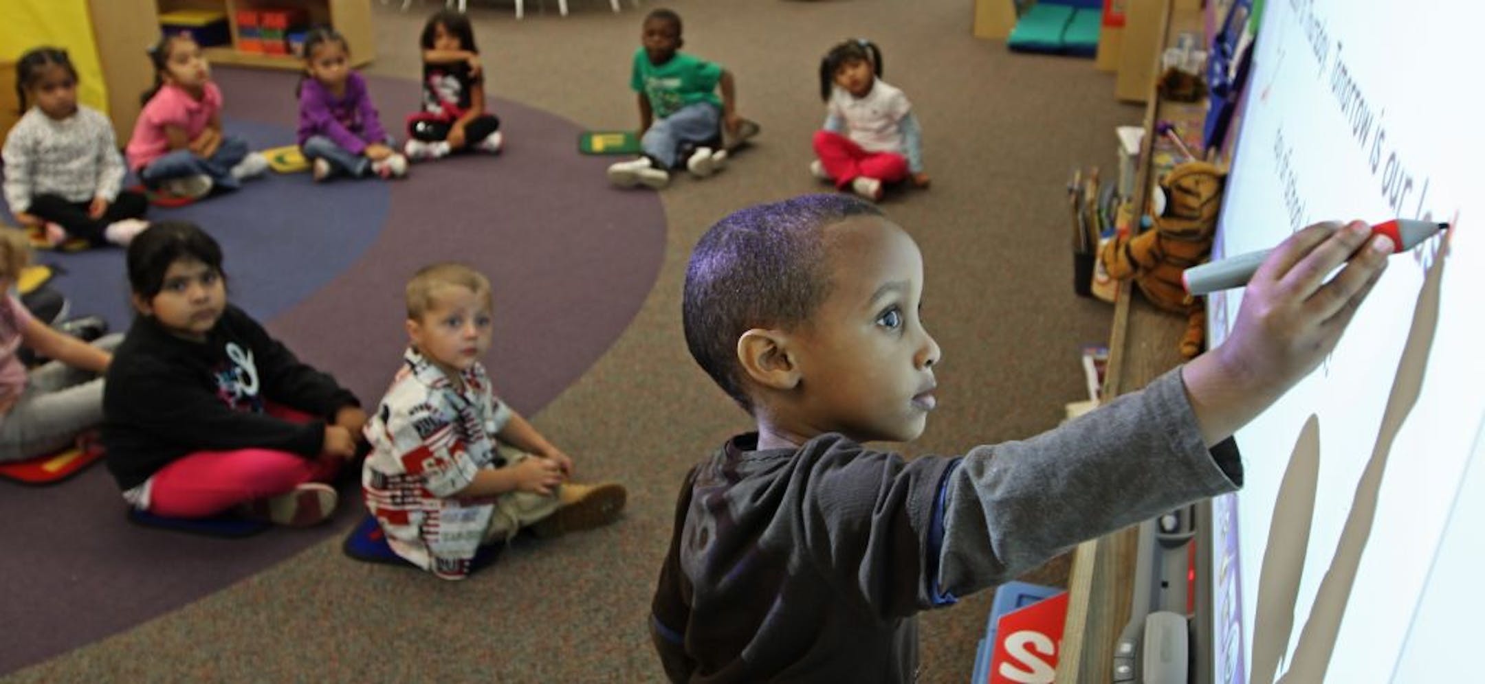 (center) Washburn Elementary School KinderPrep student Muhsin Hussein pointed out letters of the alphabet during April Walker's morning class, as other students looked on, 9/22/2011. Bruce Bisping/Star Tribune. Muhsin Hussein, April Walker/source.