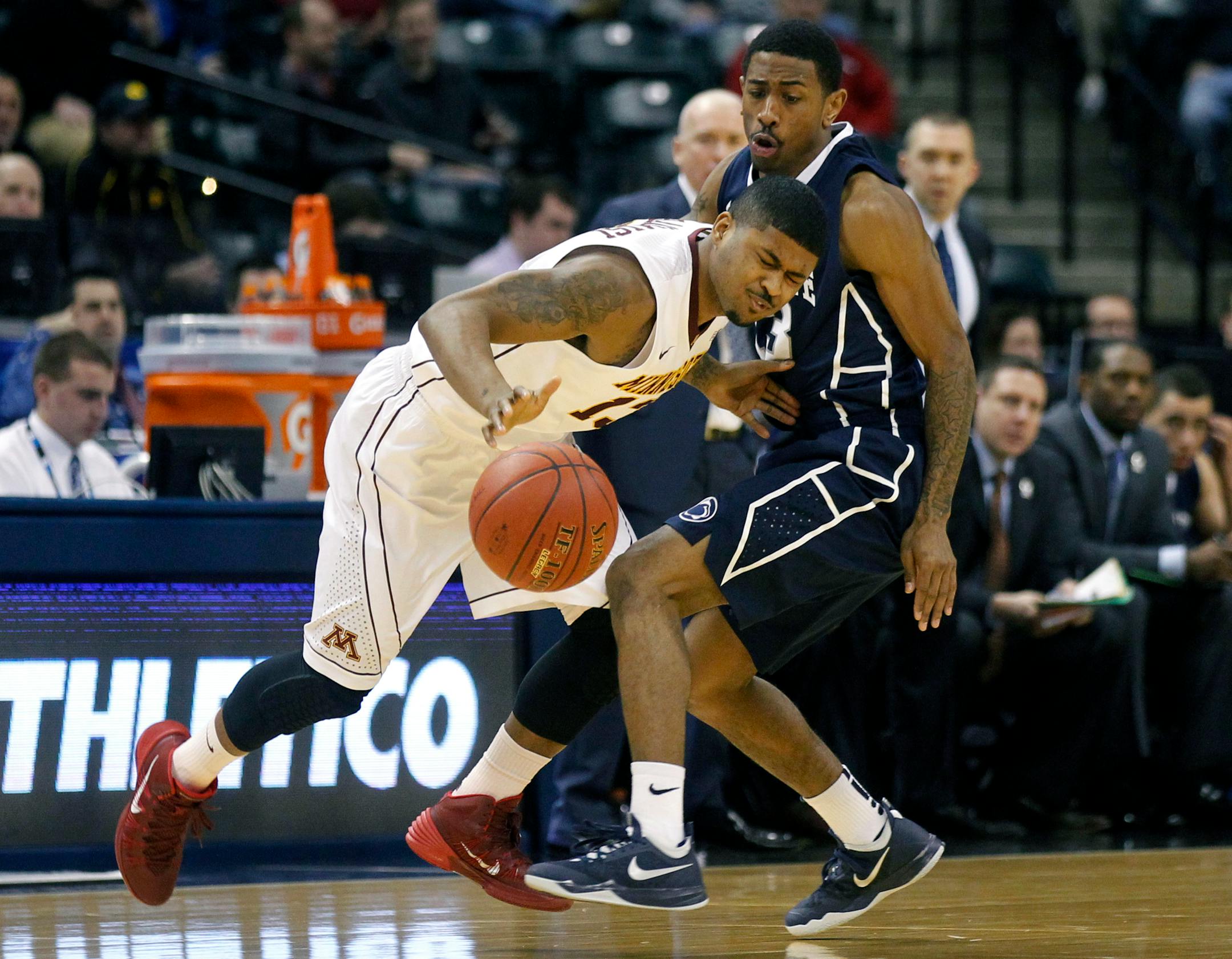 Minnesota guard Maverick Ahanmisi, left, collides with Penn State guard Geno Thorpe in the first half of an NCAA college basketball game in the first round of the Big Ten Conference tournament, Thursday, March 13, 2014, in Indianapolis. (AP Photo/Kiichiro Sato)