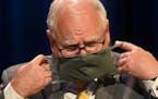 Minnesota Gov. Tim Walz donned his face mask at the end of a news conference in July.