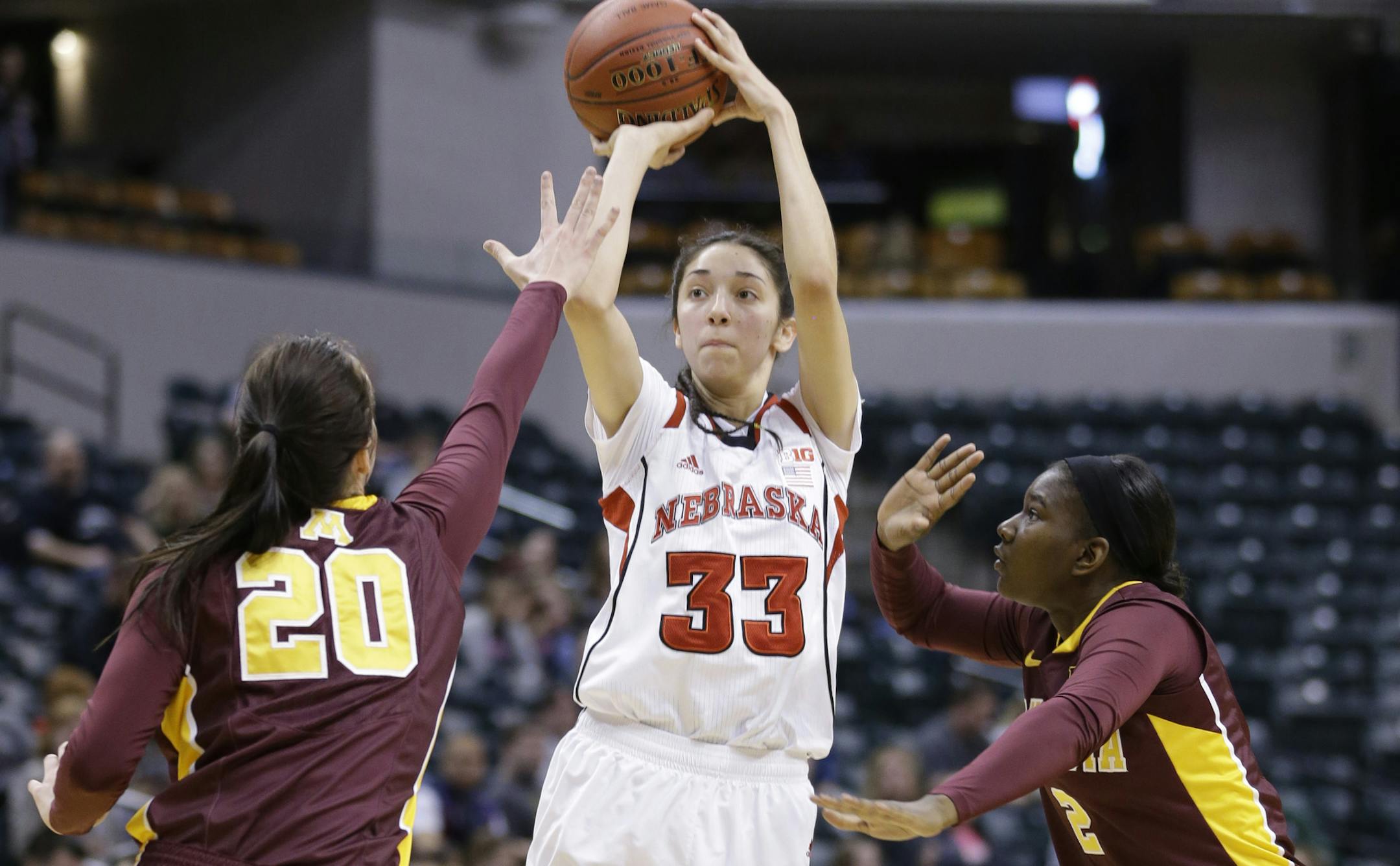 Nebraska guard Rachel Theriot, (33) pulls up for a shot between Minnesota forward Kayla Hirt (20) and guard Stabresa McDaniel in the first half of an NCAA college basketball game in the quarterfinals of the Big Ten women's tournament in Indianapolis, Friday, March 7, 2014. (AP Photo/Michael Conroy)