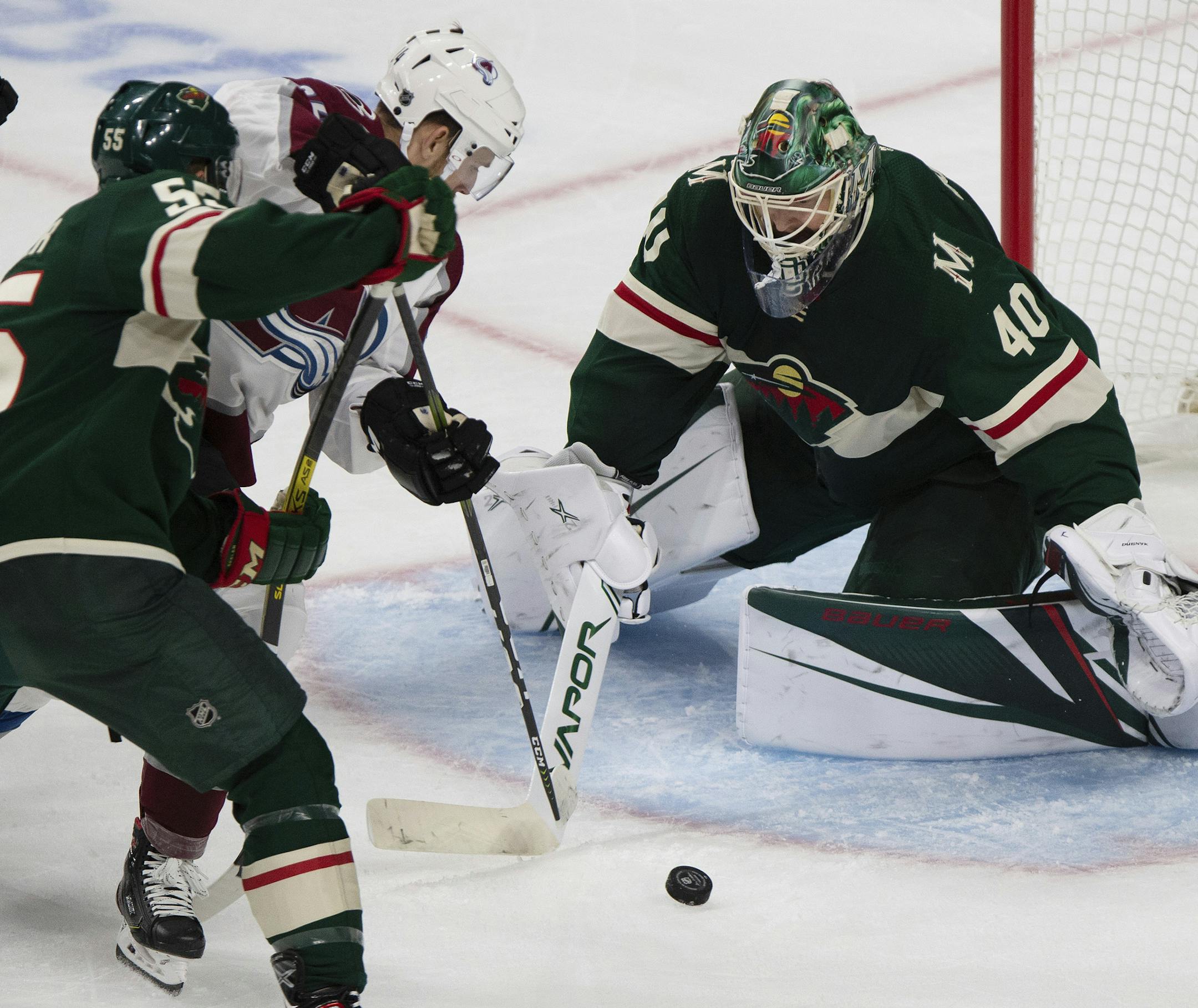 Minnesota Wild goalie Devan Dubnyk watches the puck as Colorado Avalanche's A.J. Greer tries to shoot it into the net during the first period of an NHL hockey game Saturday, Sept. 21, 2019, in St. Paul, Minn. (AP Photo/Stacy Bengs)
