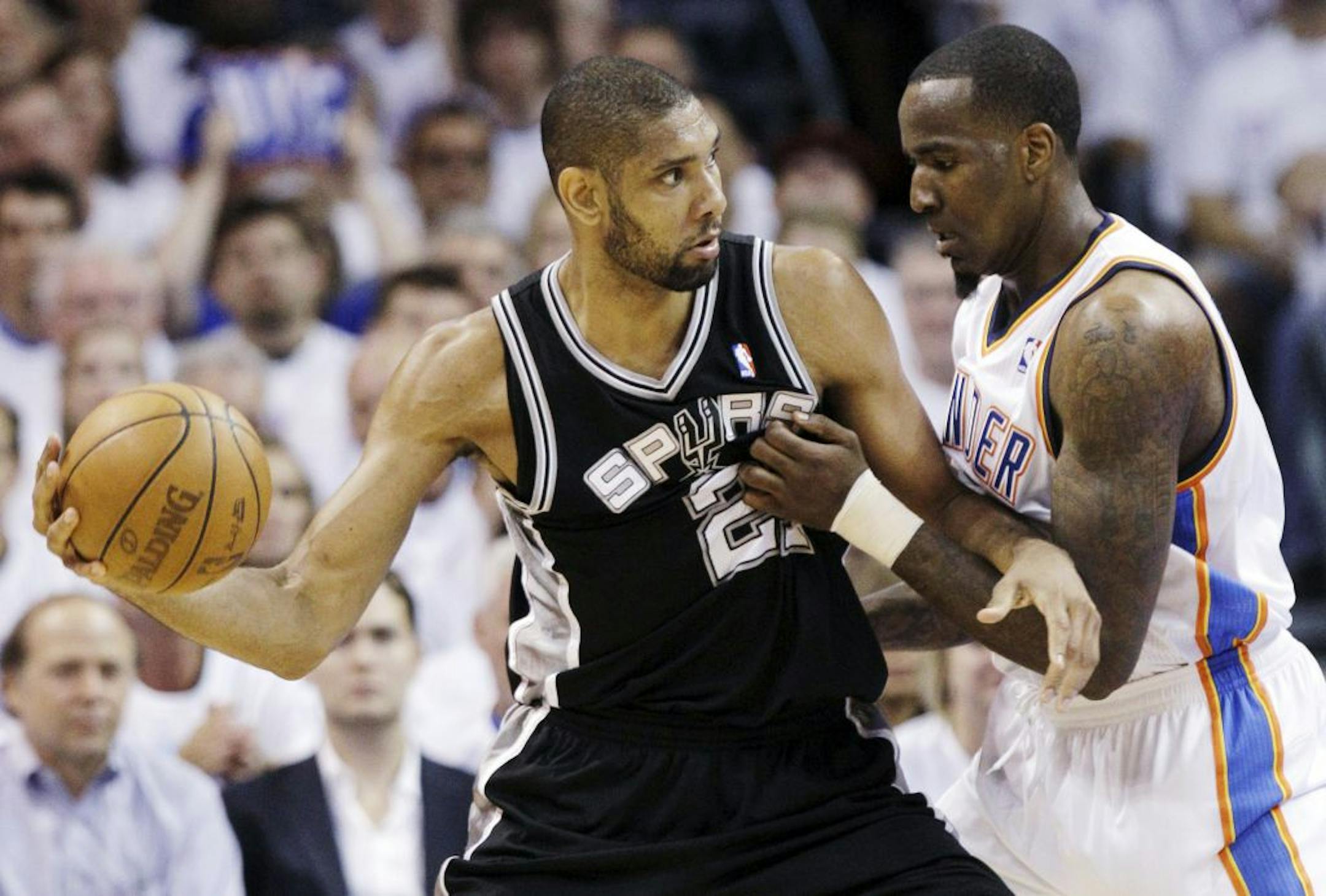 San Antonio Spurs center Tim Duncan (21) is defended by Oklahoma City Thunder center Kendrick Perkins (5) during the first half of Game 6 in the NBA basketball Western Conference finals, Wednesday, June 6, 2012, in Oklahoma City.