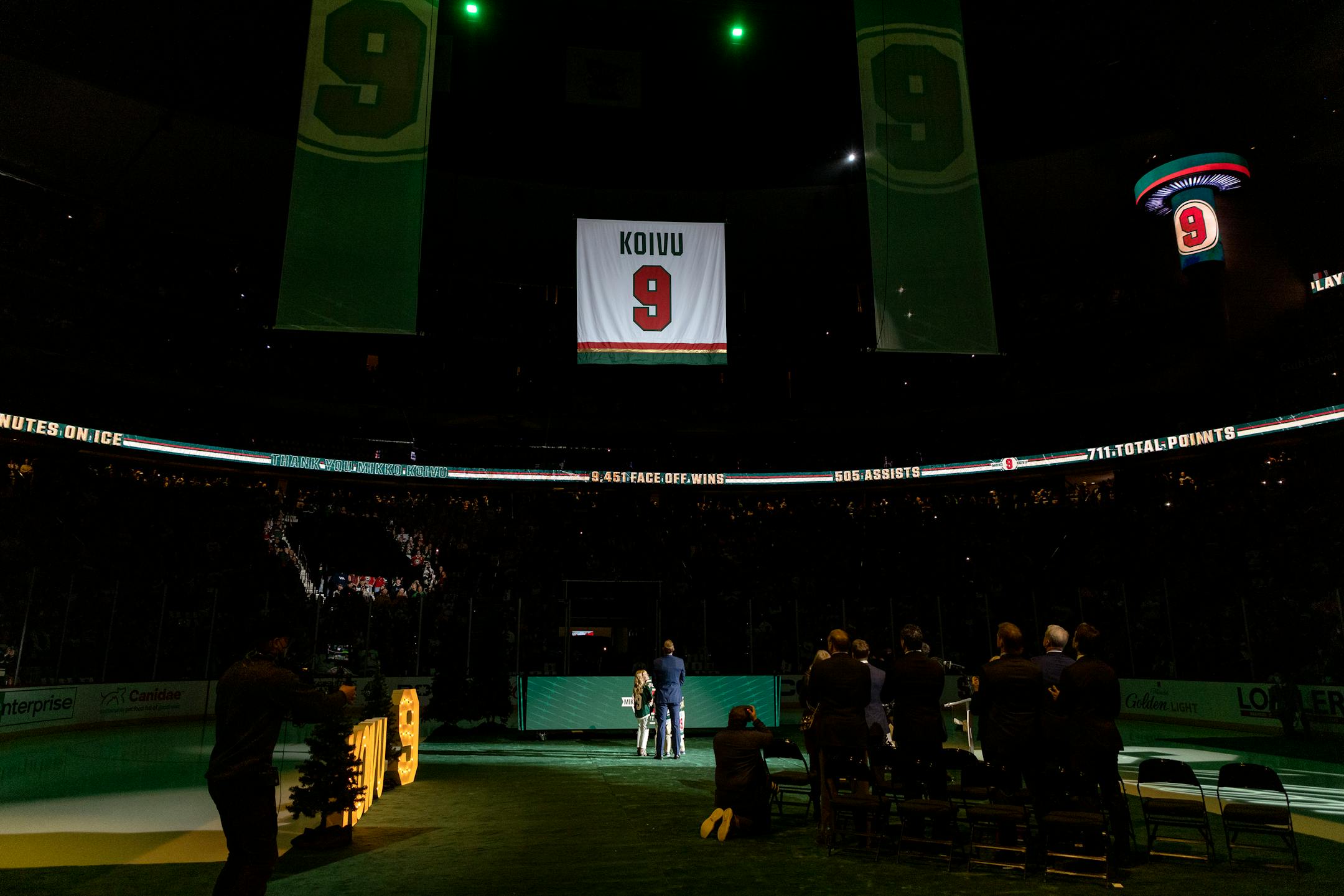 Mikko Koivu and his children watch his number lifted into the rafters during a ceremony to retire his number
