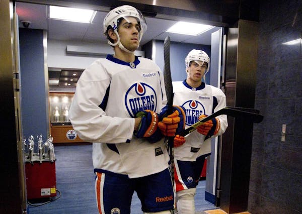 Edmonton Oilers' Justin Schultz, left, and Taylor Hall walk out of the dressing room for an informal NHL hockey workout in Edmonton, Alberta, on Wedne