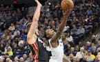 Minnesota Timberwolves' Jeff Teague, right, lays up a shot in front of Miami Heat's Meyers Leonard in the first half of an NBA basketball game Sunday,