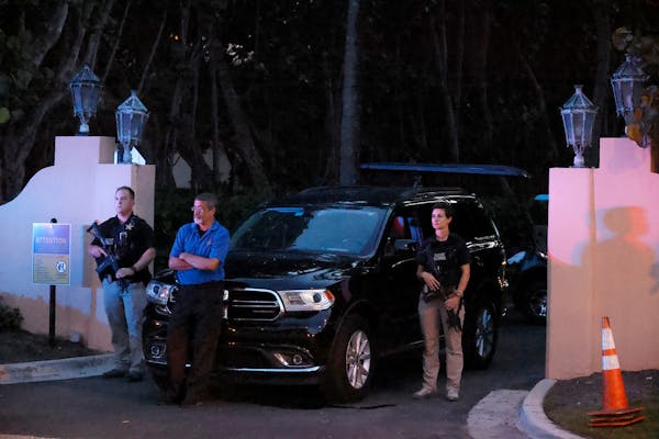 Armed Secret Service agents stand outside an entrance to former President Donald Trump's Mar-a-Lago estate, late Monday, Aug. 8, 2022, in Palm Beach, 