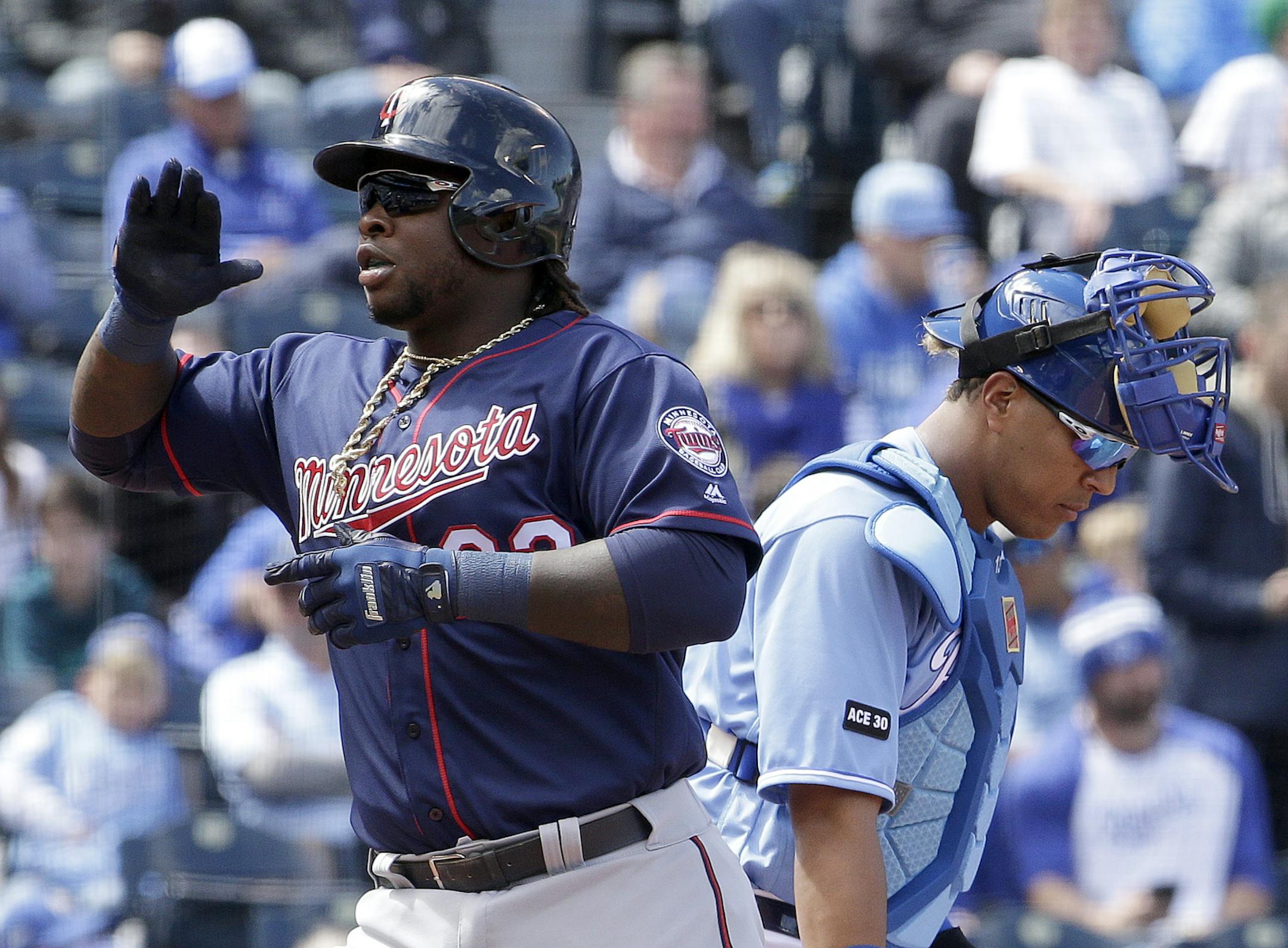 Minnesota Twins' Miguel Sano, left, crosses the plate past Kansas City Royals catcher Salvador Perez after hitting a three-run home run during the third inning of a baseball game Sunday, April 30, 2017, in Kansas City, Mo. (AP Photo/Charlie Riedel)