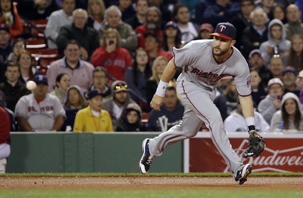 Minnesota Twins third baseman Trevor Plouffe moves to field a ground out by Boston Red Sox's Mookie Betts in the eighth inning of a baseball game at F