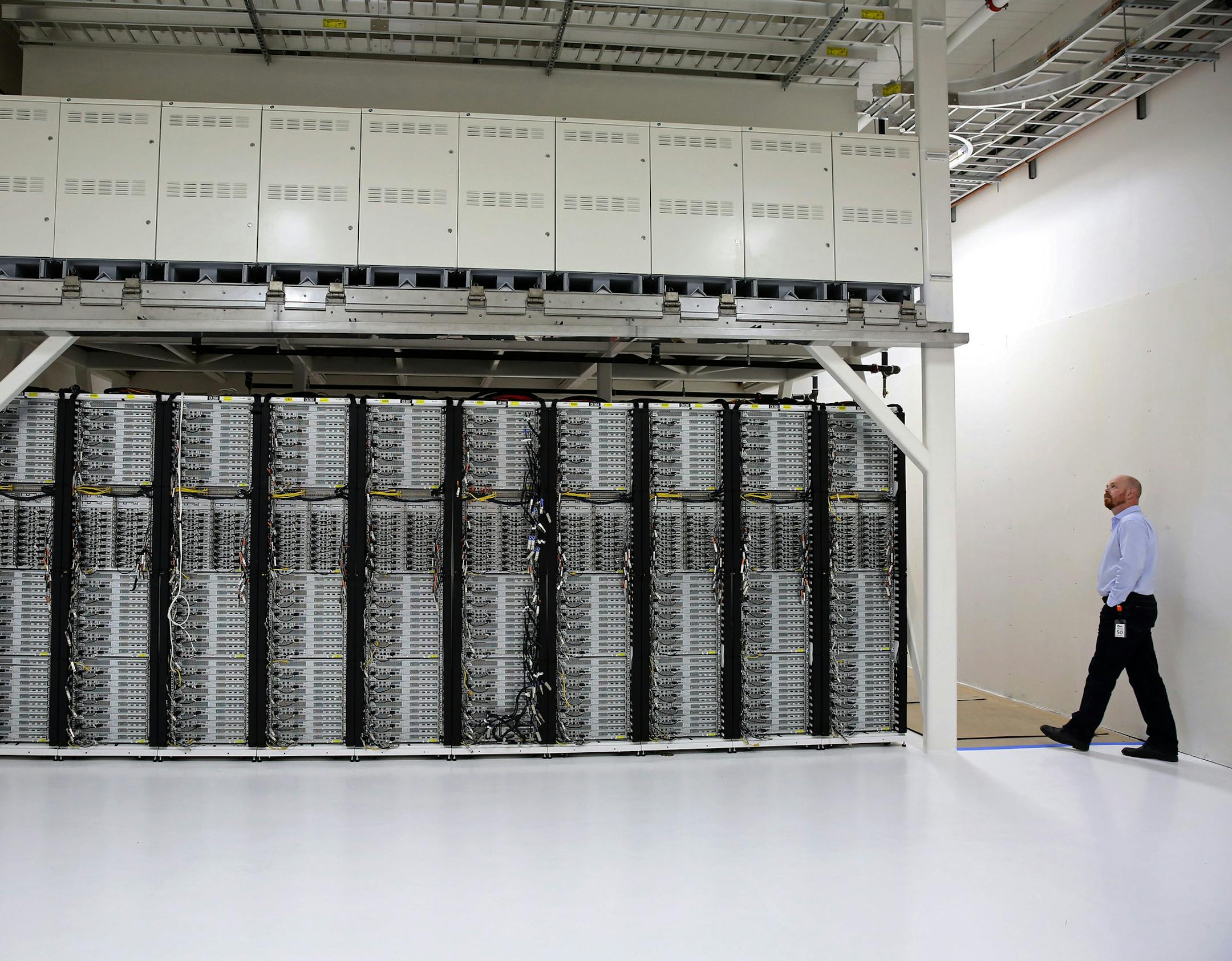 Microsoft engineer Sean James is dwarfed by the superstructure frame that supports servers on the bottom and European-made fuel cells on top at a building in Sodo. The company hopes to begin testing soon using natural-gas-powered fuel cells to power data centers. (Ken Lambert/Seattle Times/TNS)