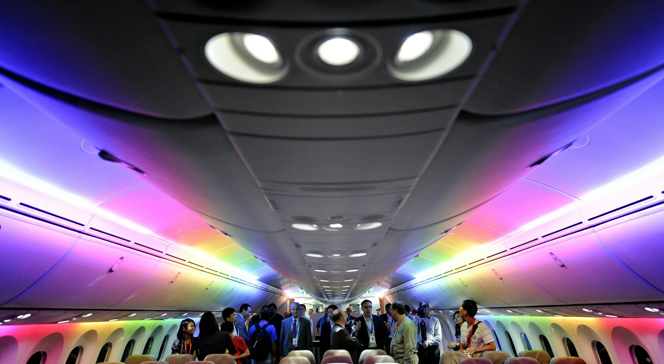 FILE - In this Feb. 12, 2012, file photo, members of the media tour Boeing 787 Dreamliner's cabin displaying versatile LED lighting system during a press preview in Singapore. While Boeingís 787 Dreamliners are grounded, the batteries causing airlinerís troubles can still fly. At the time the government certified the 787 as safe, federal rules barred the type of batteries used to power the airlinerís electrical systems from being carried as cargo on passenger planes because of the