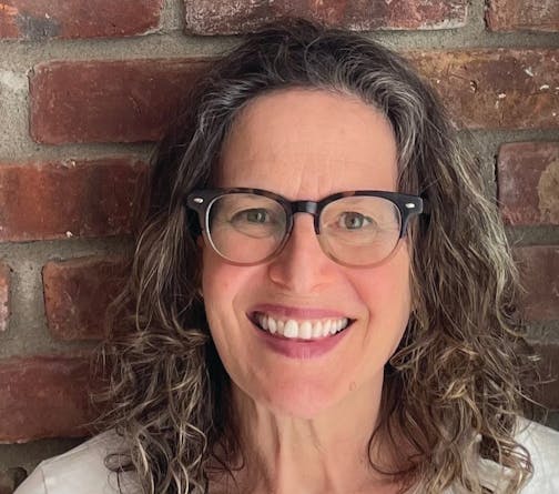 photo of author Catherine Newman in front of a brick wall