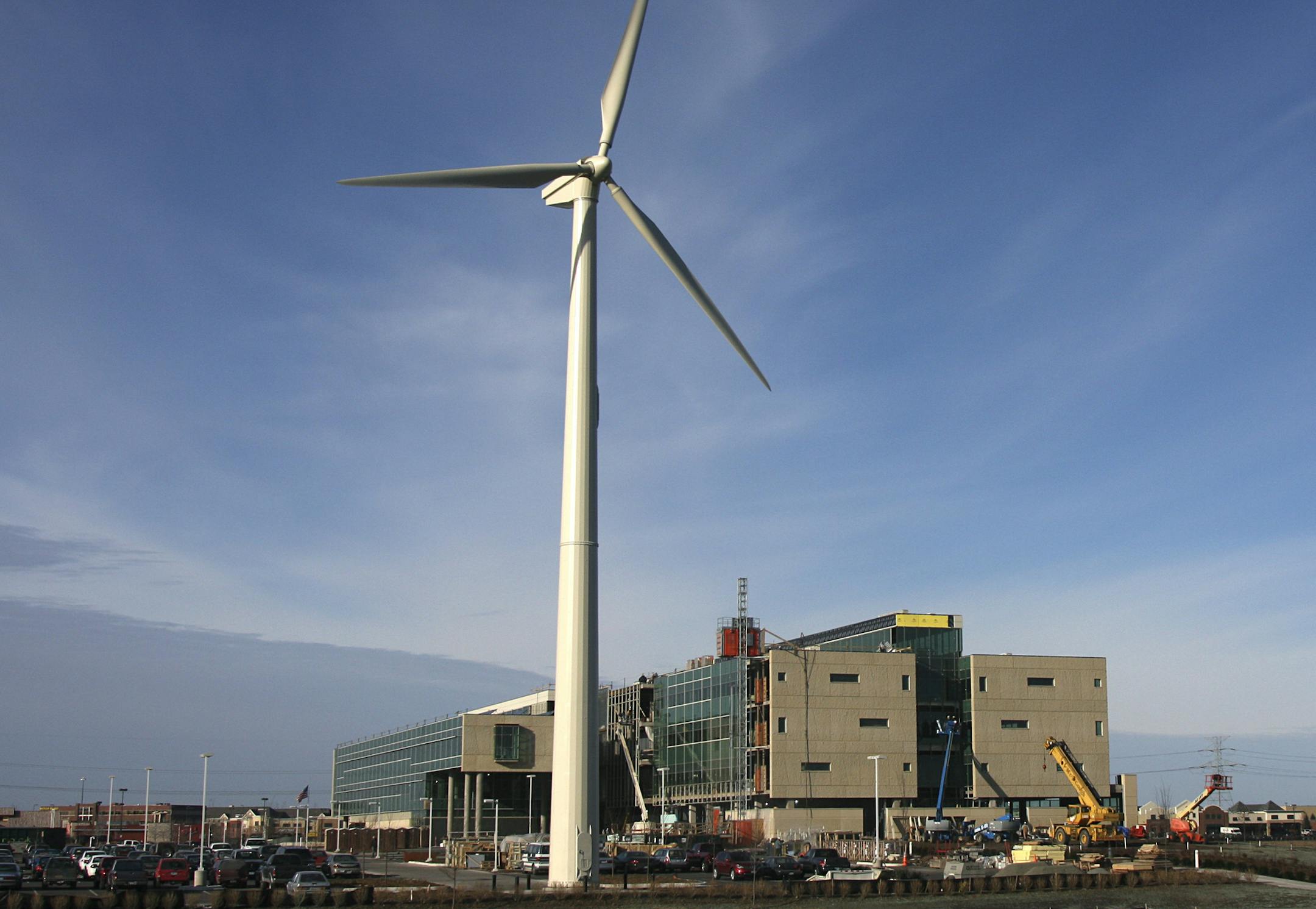 A wind turbine dwarfs the Great River Energy building in Maple Grove. Its energy sales were up 6 percent through May.